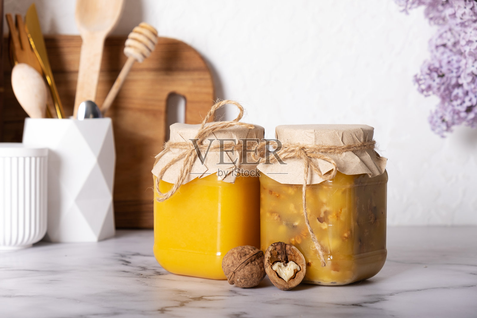 装满蜂蜜和核桃的罐子。厨房里的蜂蜜核桃照片摄影图片