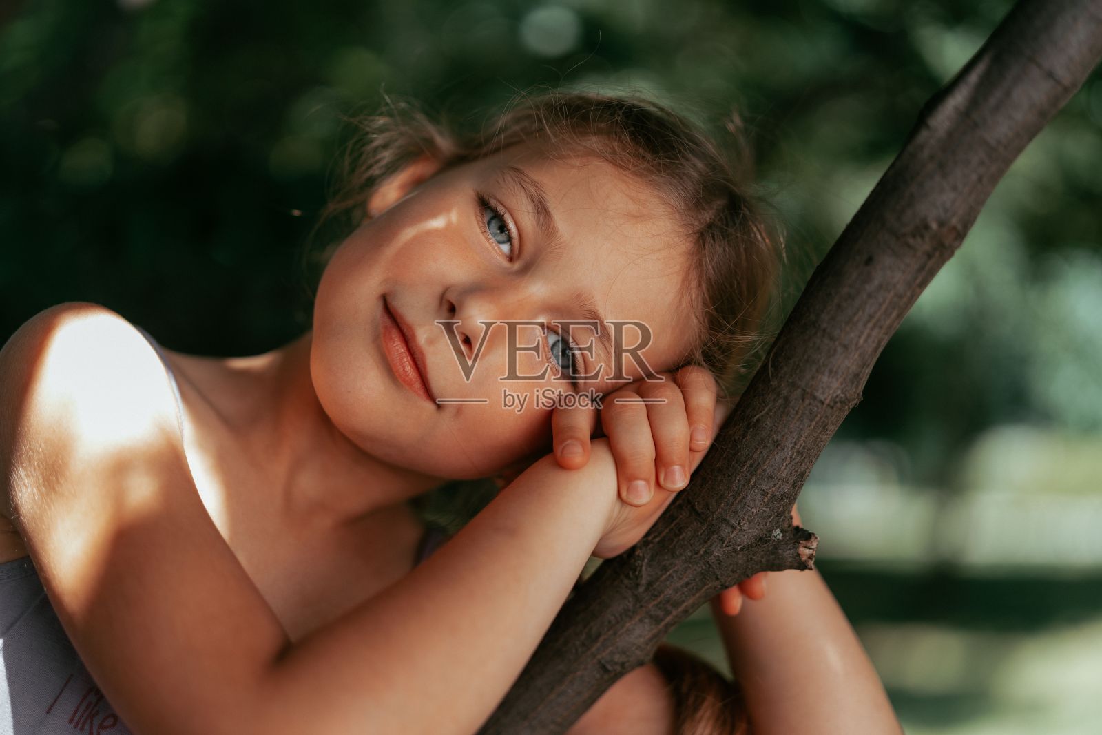 公园里一个小女孩一只手抓着树枝照片摄影图片