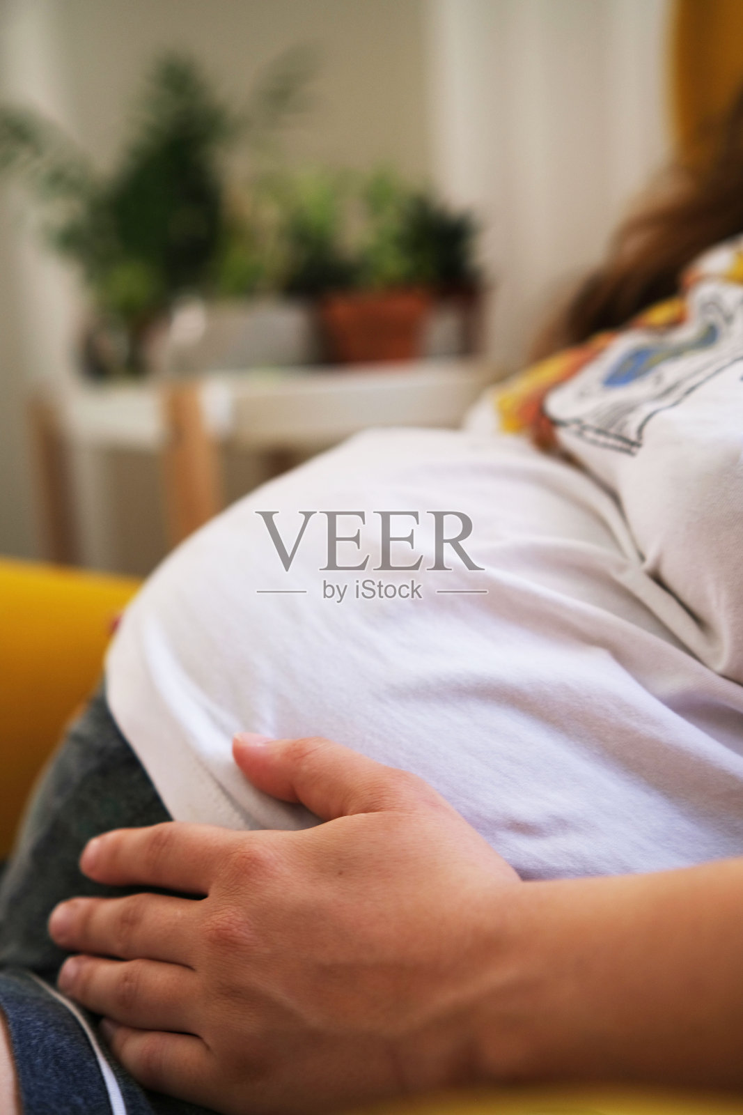 怀孕的年轻女子在家中休息。照片摄影图片