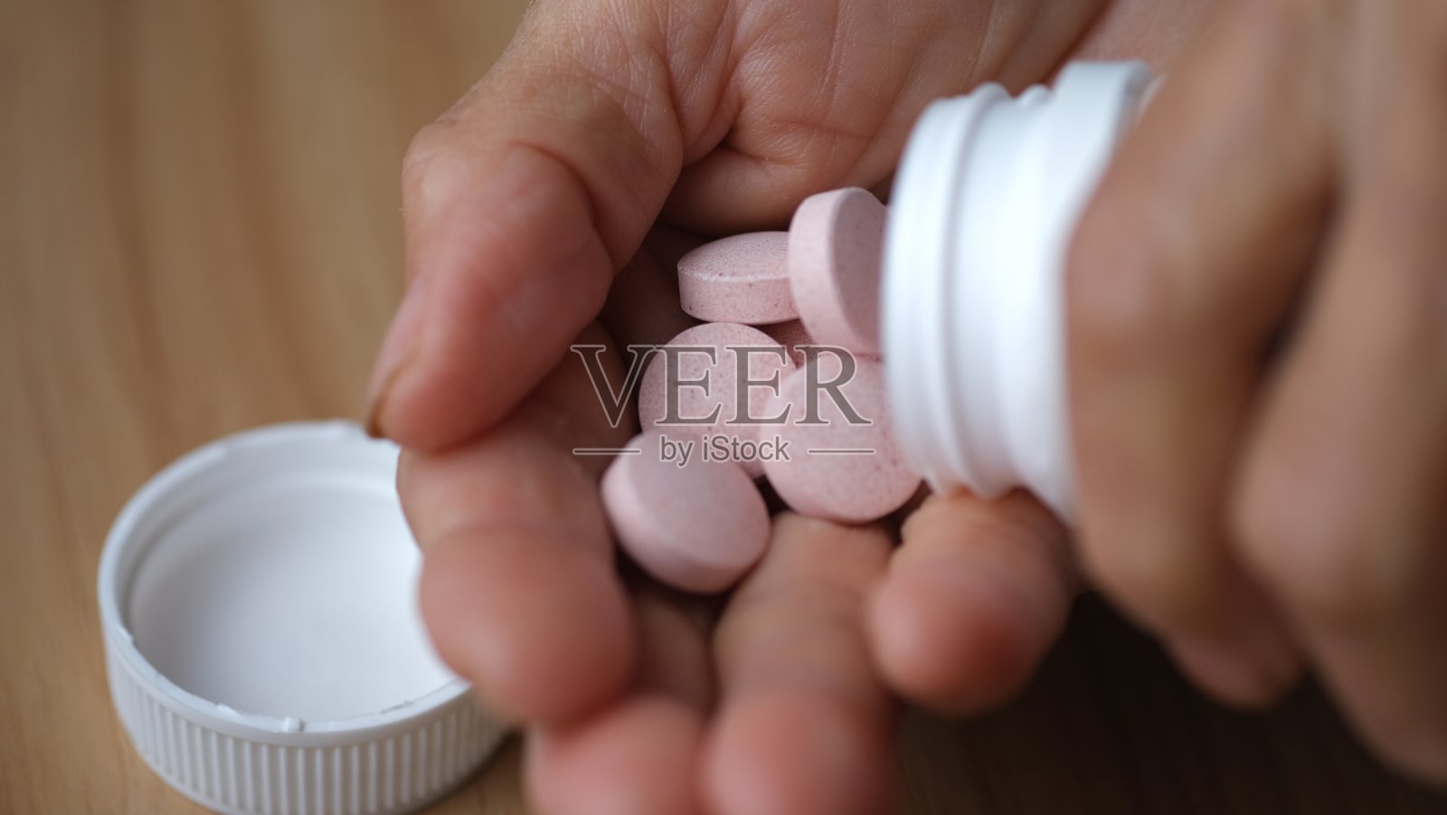 将维生素或补充剂片倒在手里照片摄影图片