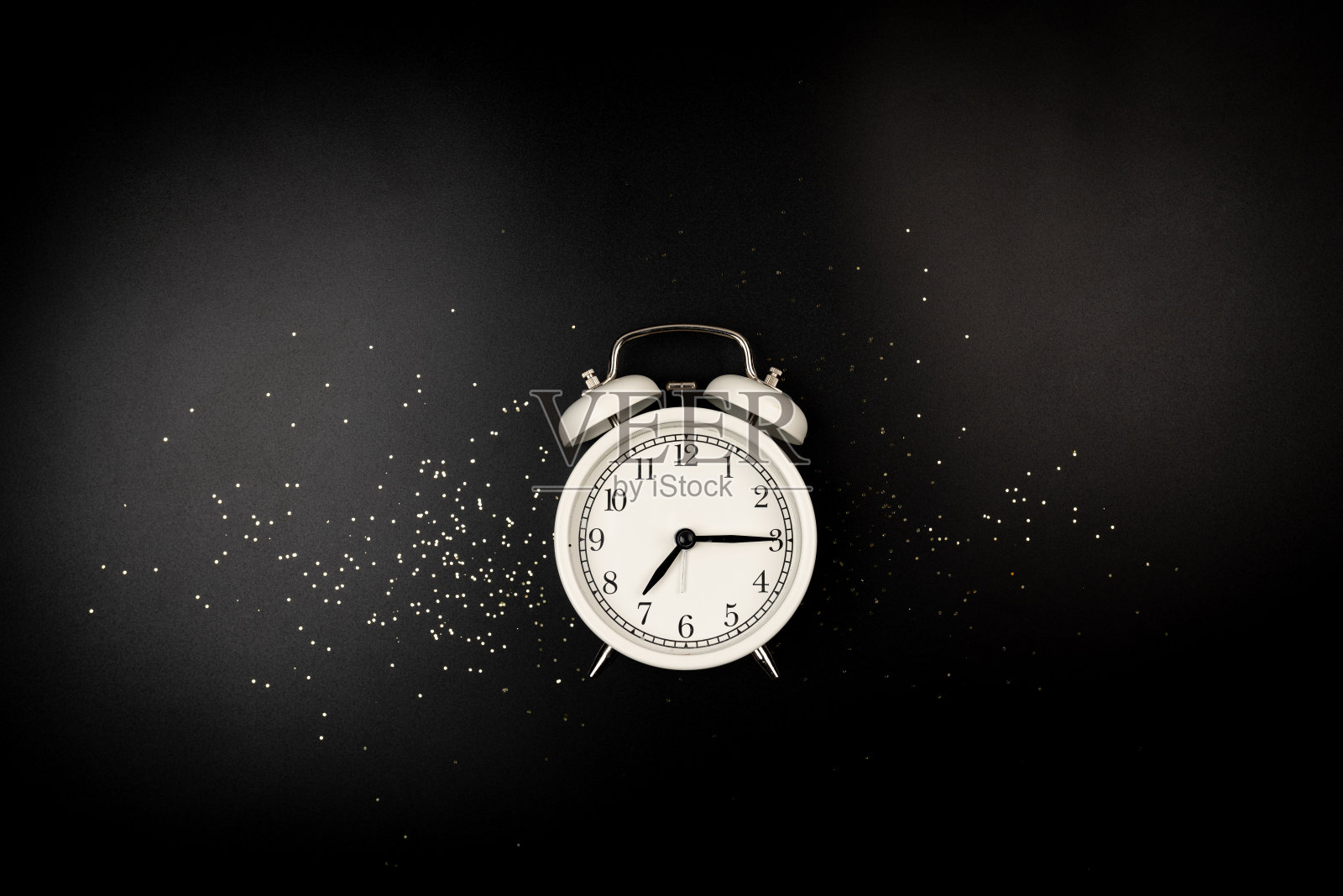 平躺着白色的闹钟照片摄影图片