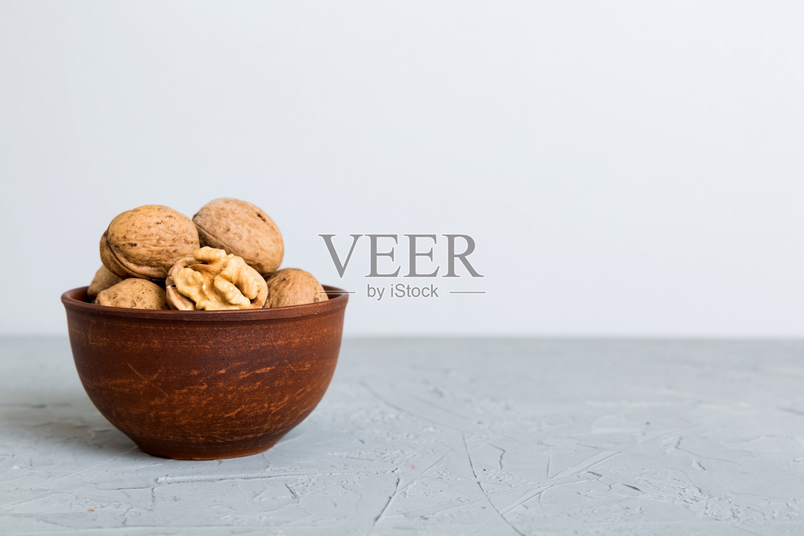 新鲜健康的核桃在碗在彩色的桌子背景。健康饮食bertholletia概念。超级食物照片摄影图片