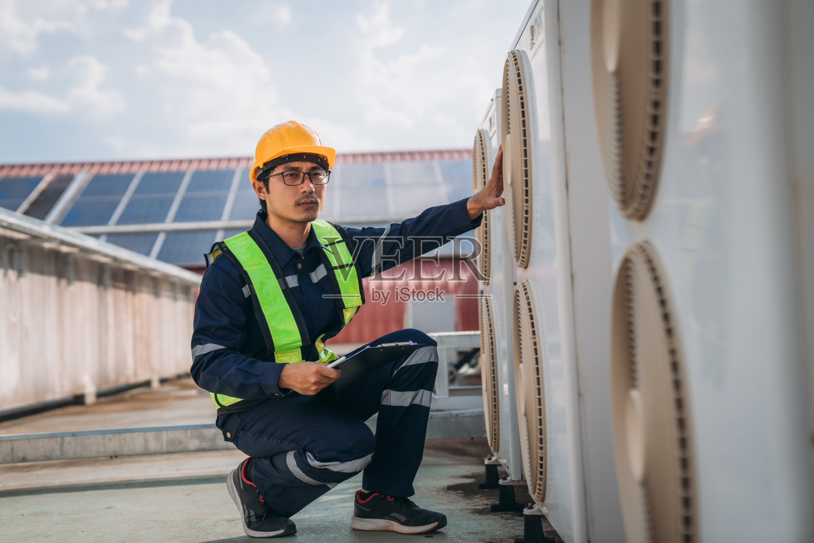 工程师正在检查一幢主要建筑或工业设施的空调冷却系统。照片摄影图片