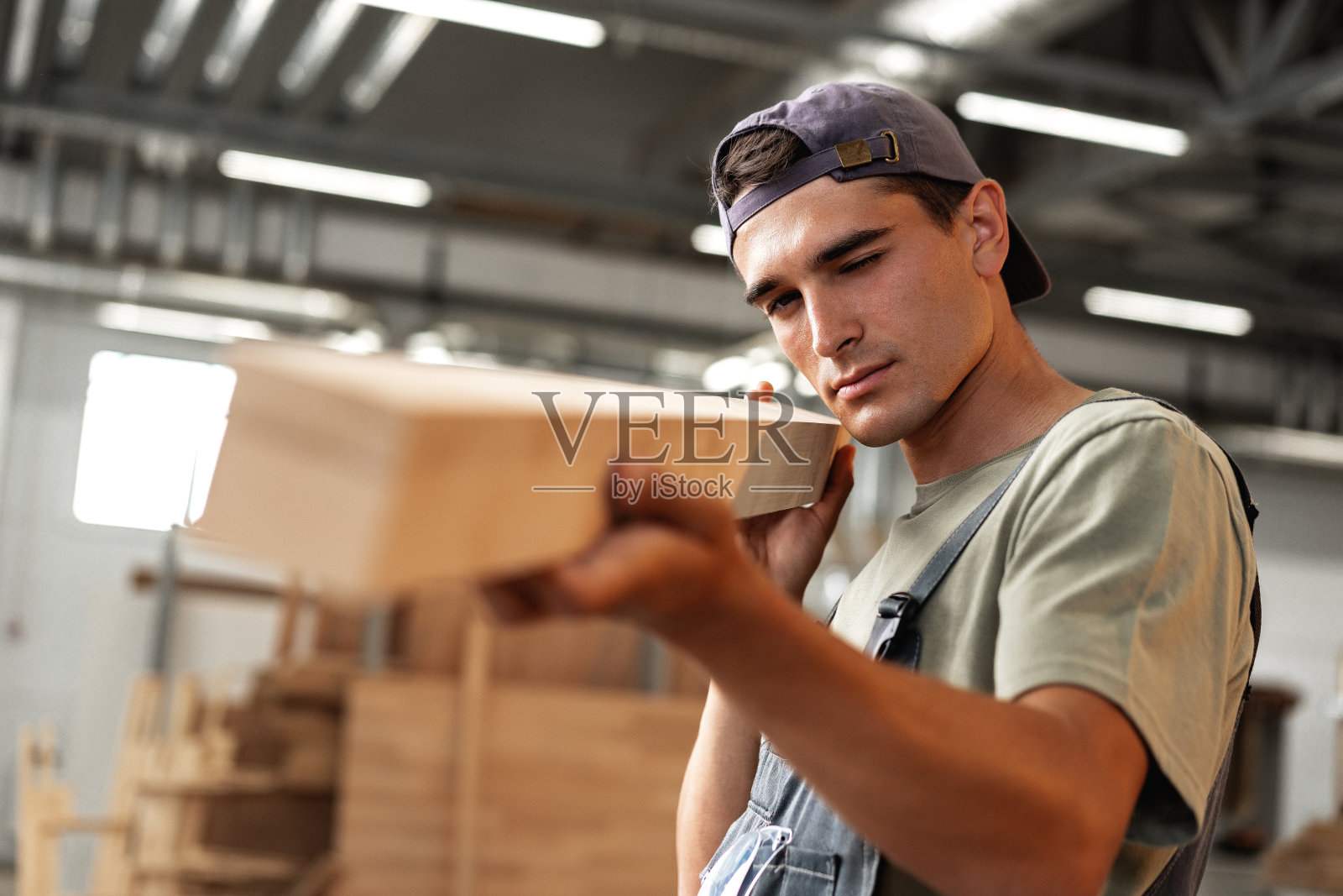 年轻的木匠在木工工厂的车间里挑选木板照片摄影图片