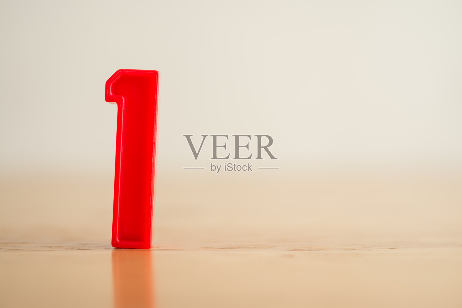 红色塑料1号(一个)标志立在白色背景的木桌上。照片摄影图片