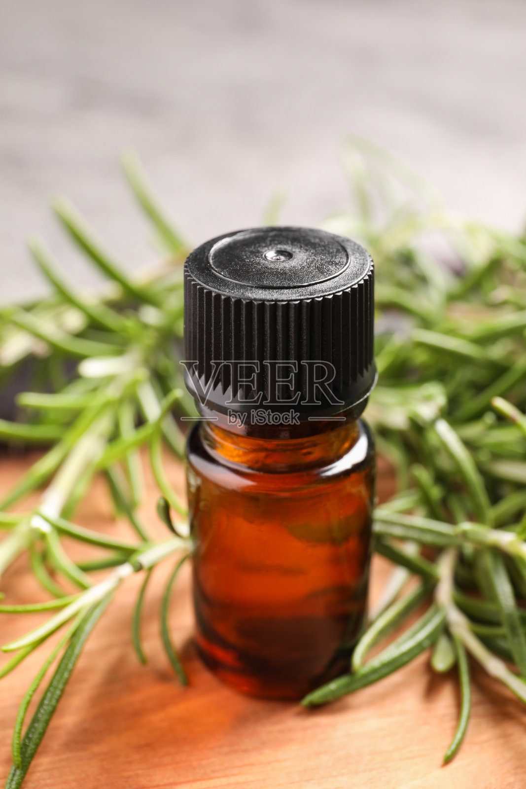 船上有一瓶精油和新鲜迷迭香,特写照片摄影图片