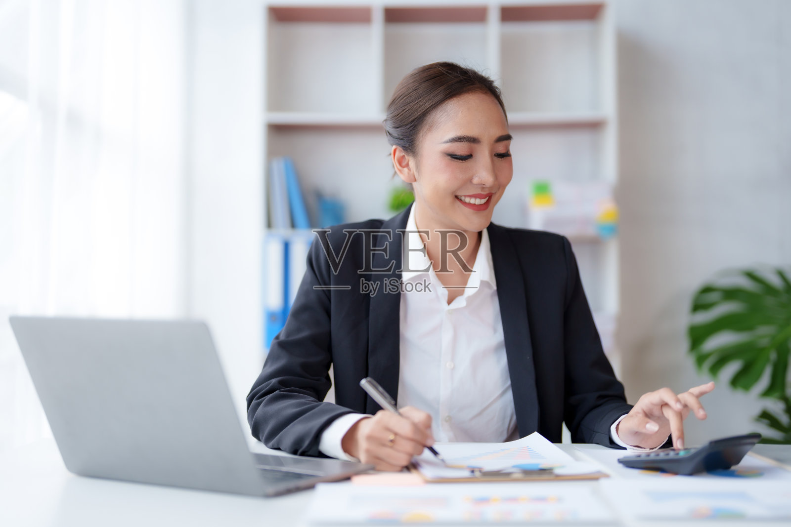 年轻的亚洲女商人使用计算器计算商业会计财务原理。办公室的会计统计概念。照片摄影图片