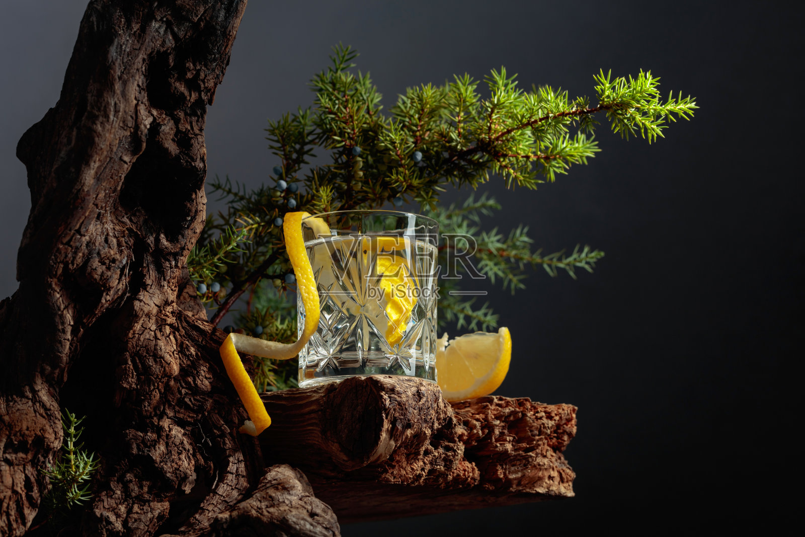 鸡尾酒杜松子酒加柠檬在一个旧板上的水晶杯。照片摄影图片