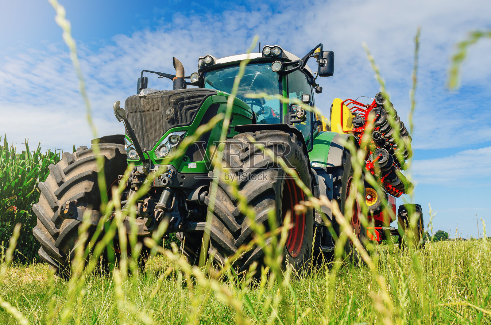 创意农业景观。从低角度看草地上的拖拉机。照片摄影图片