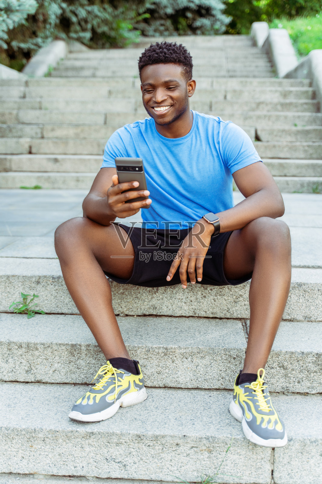 积极的年轻非裔美国人拿着手机看视频照片摄影图片