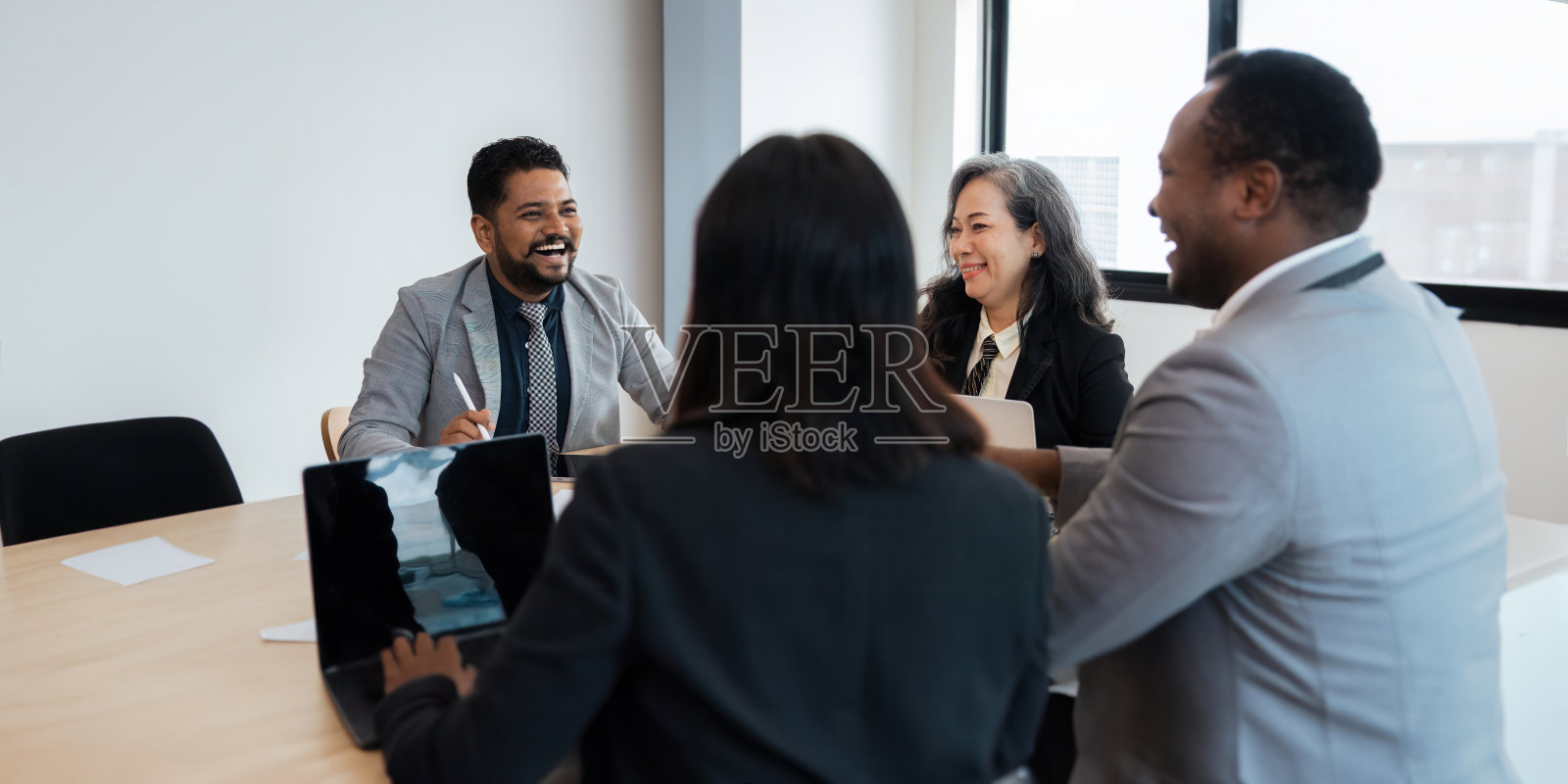 把不同种族的商人分组在一起分析财务数据报告办公室会议桌上的文件照片摄影图片