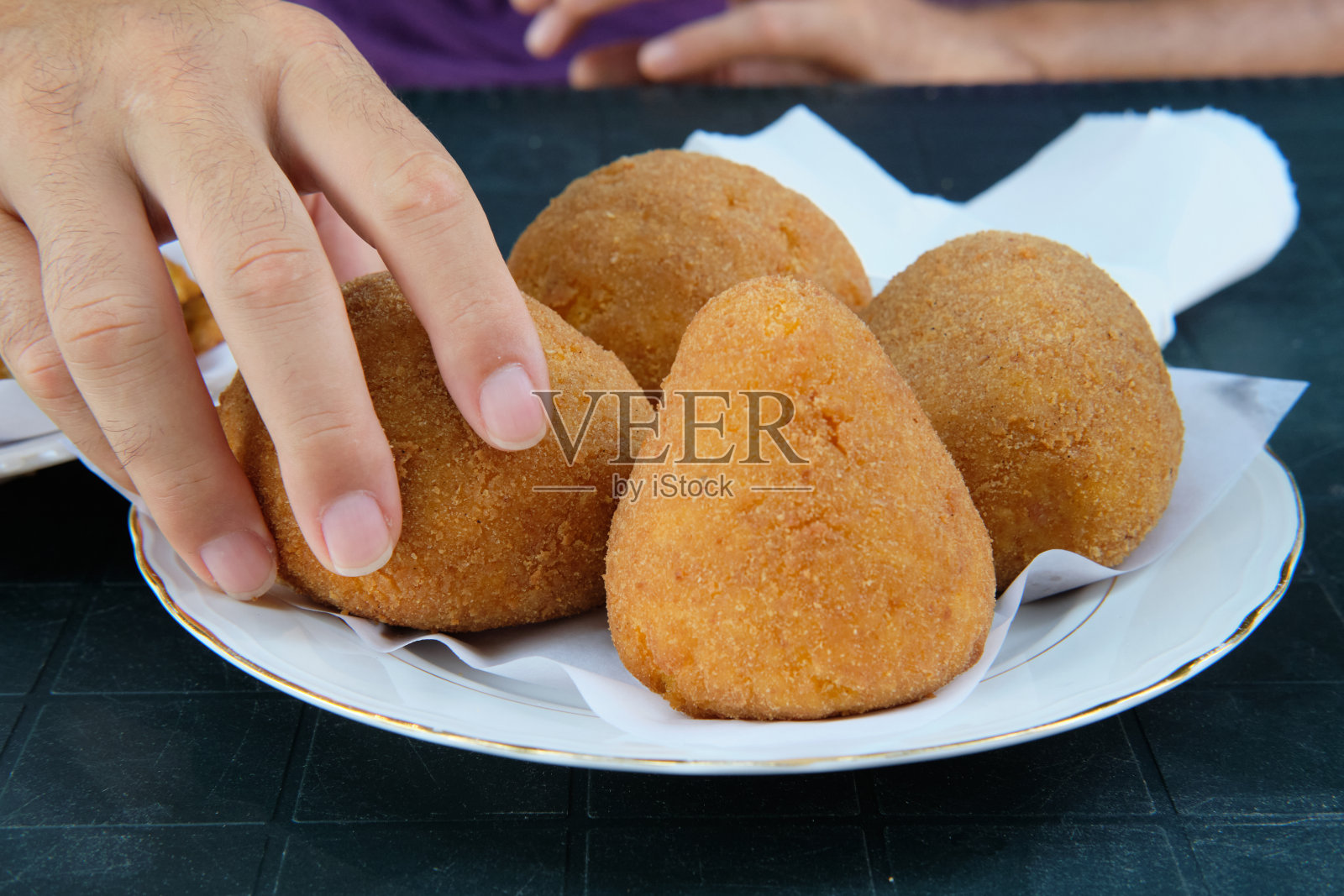 手拿油炸饭团照片摄影图片