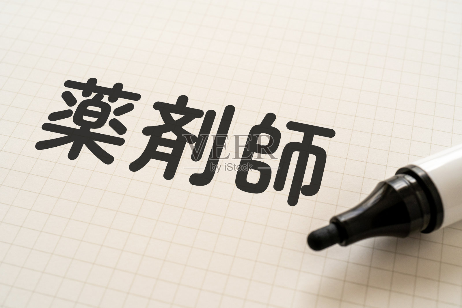 白纸上用记号笔写着“yakuzaishi”。照片摄影图片