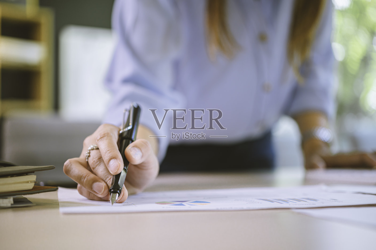 商人用笔指着商业报告图表,用图表和文件进行商业分析。照片摄影图片