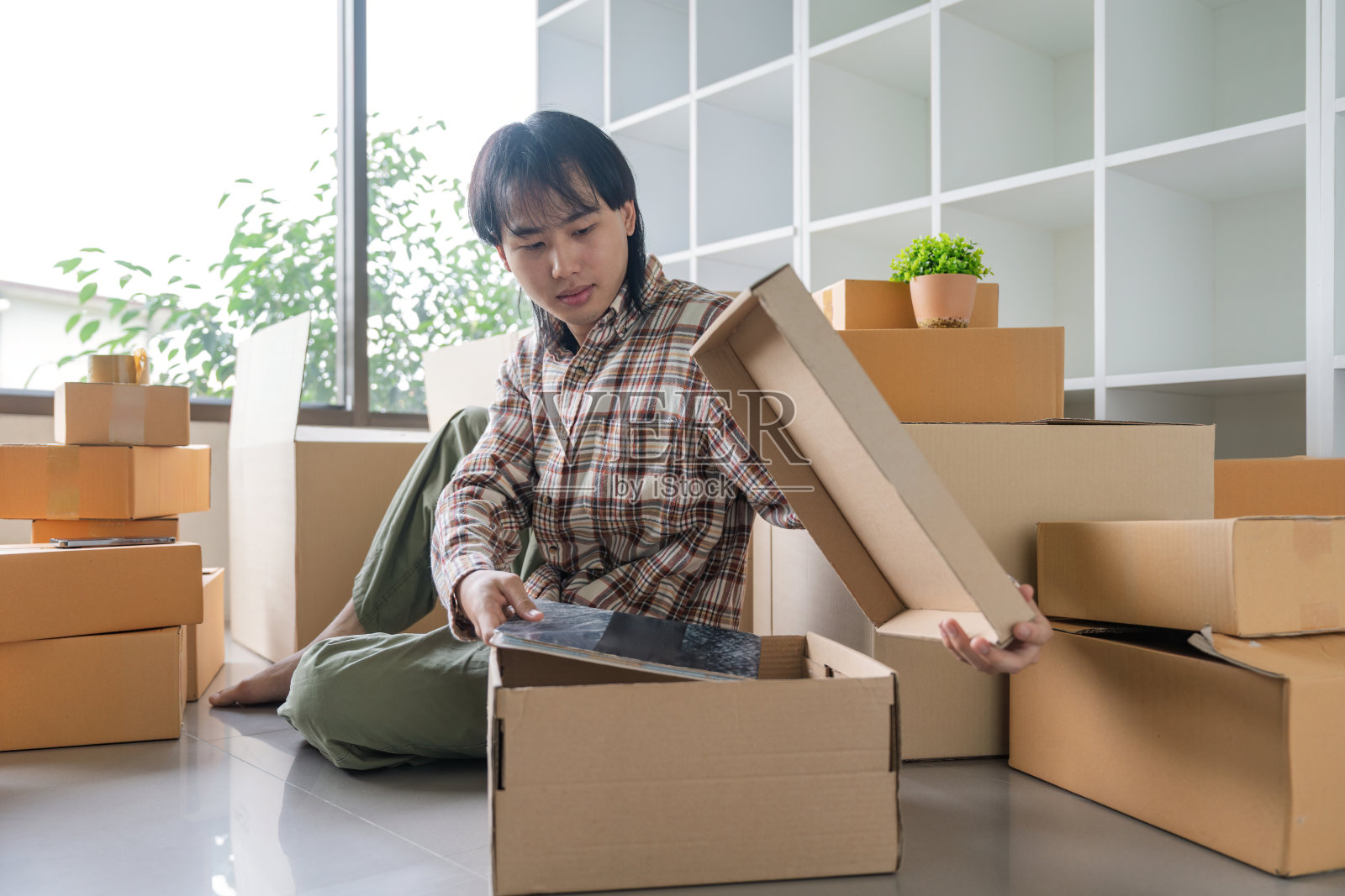 搬家时将物品装箱的亚洲男人照片摄影图片