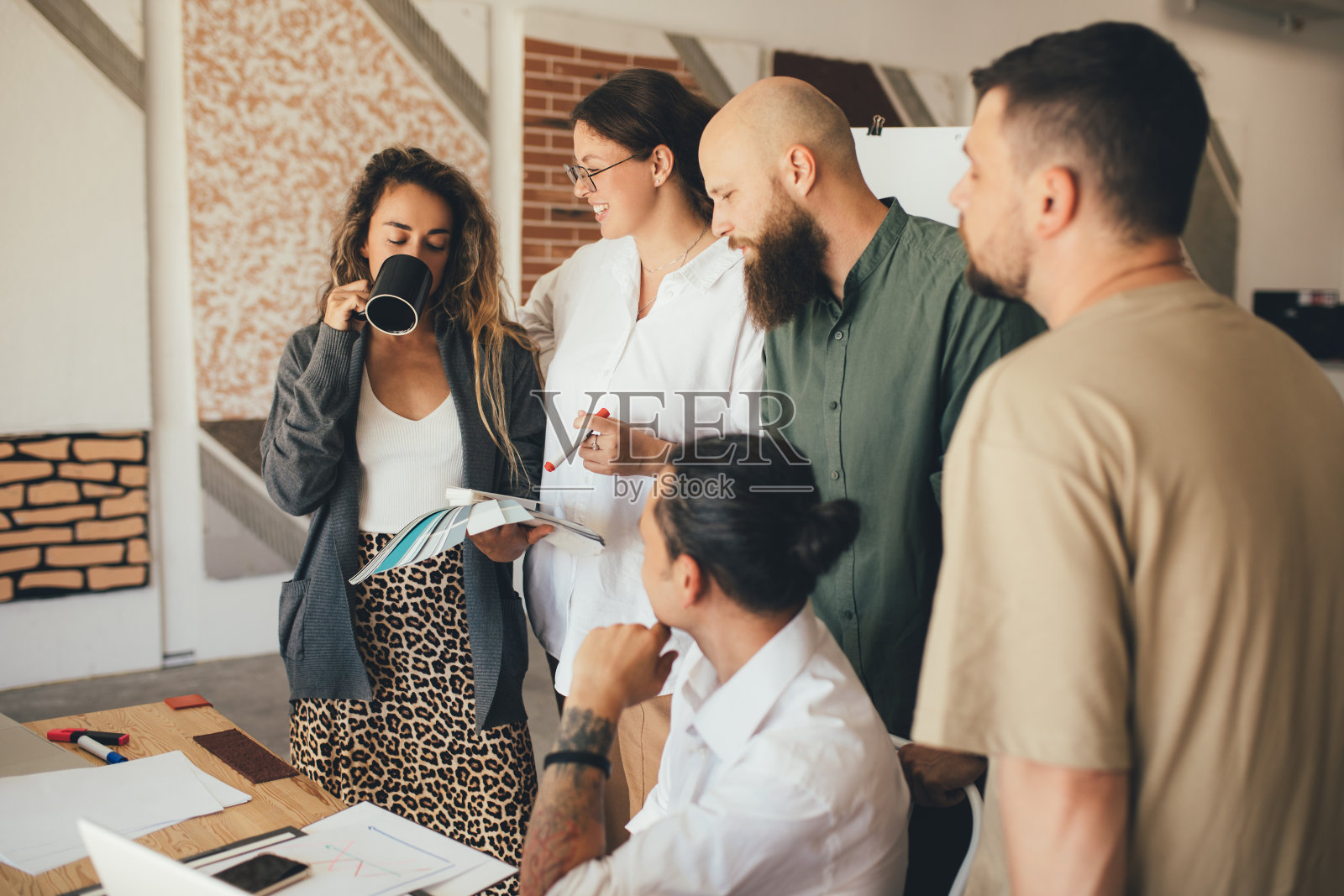 一群年轻的设计师在一间现代化的办公室里开会。照片摄影图片