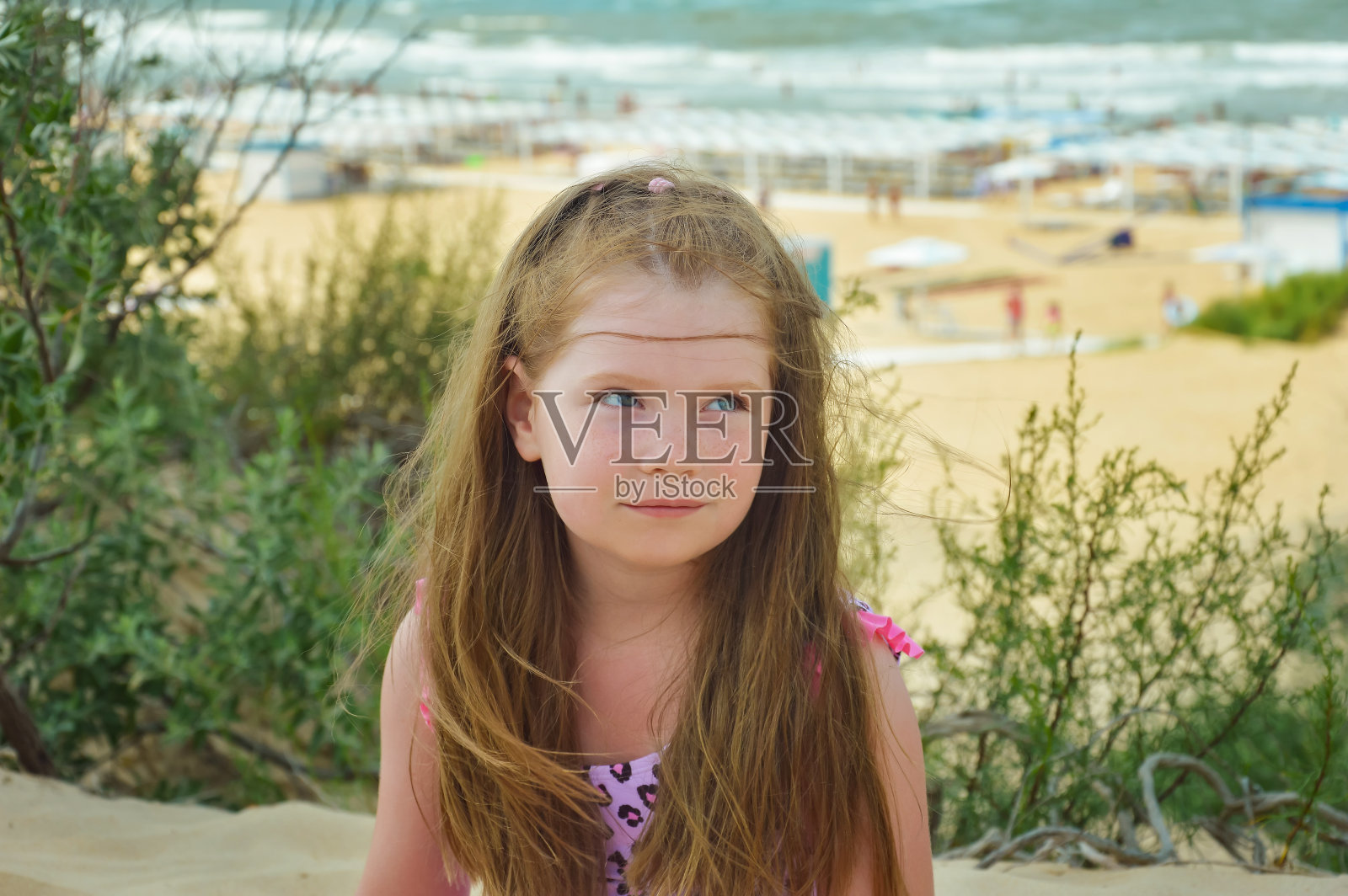 美丽的女孩,长发在沙滩和大海的背景。暑假靠水,天气晴朗。设计背景。一个穿着泳装的孩子。照片摄影图片