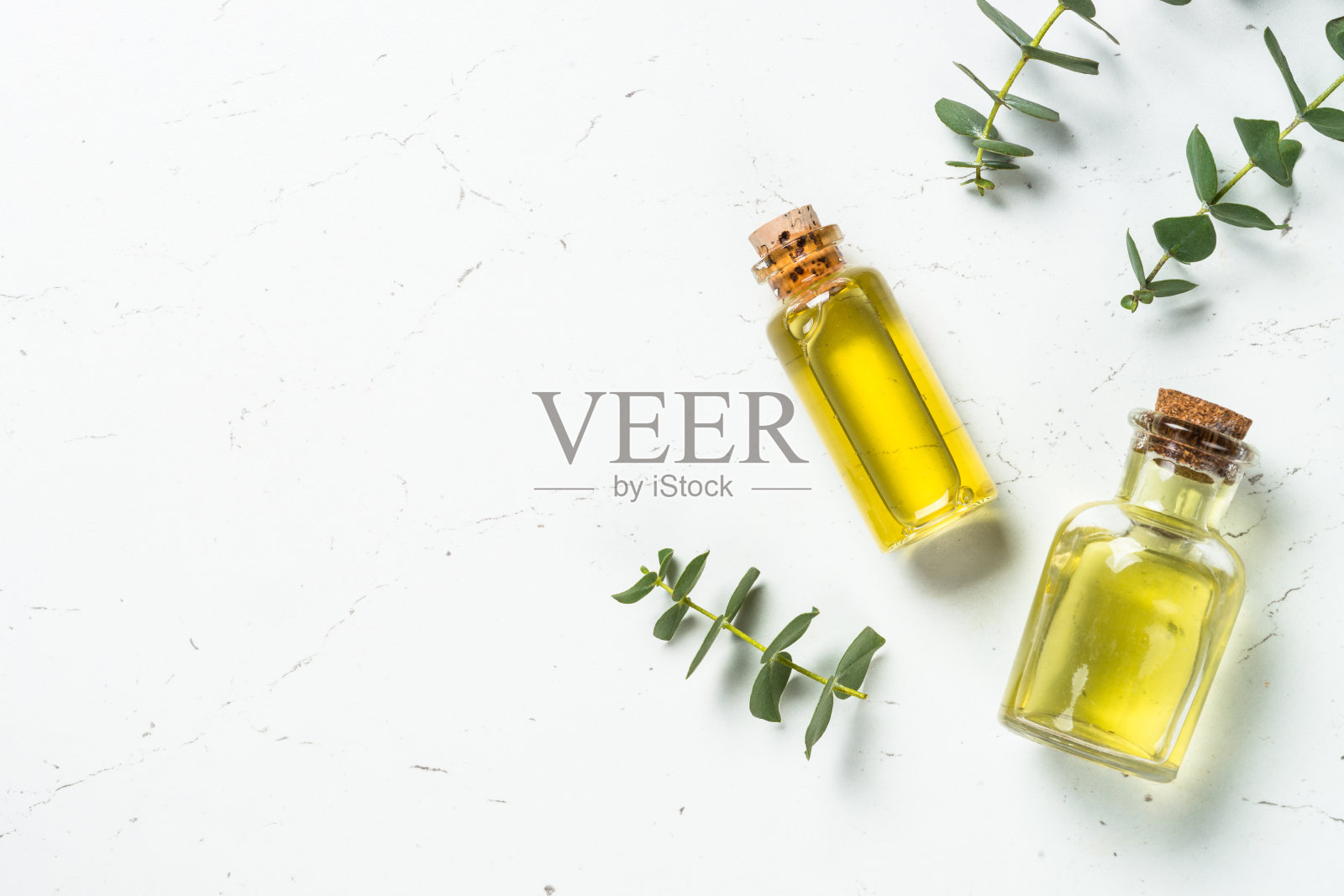 桉树油在玻璃瓶和绿色桉树叶子。照片摄影图片