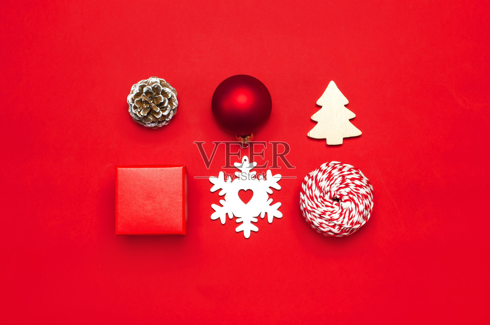 圣诞组成。新年的木制玩具,冷杉球果,红球,雪花,礼物在红色背景上缠绕平铺顶部查看复制空间。圣诞冬季装饰,自然新年理念照片摄影图片