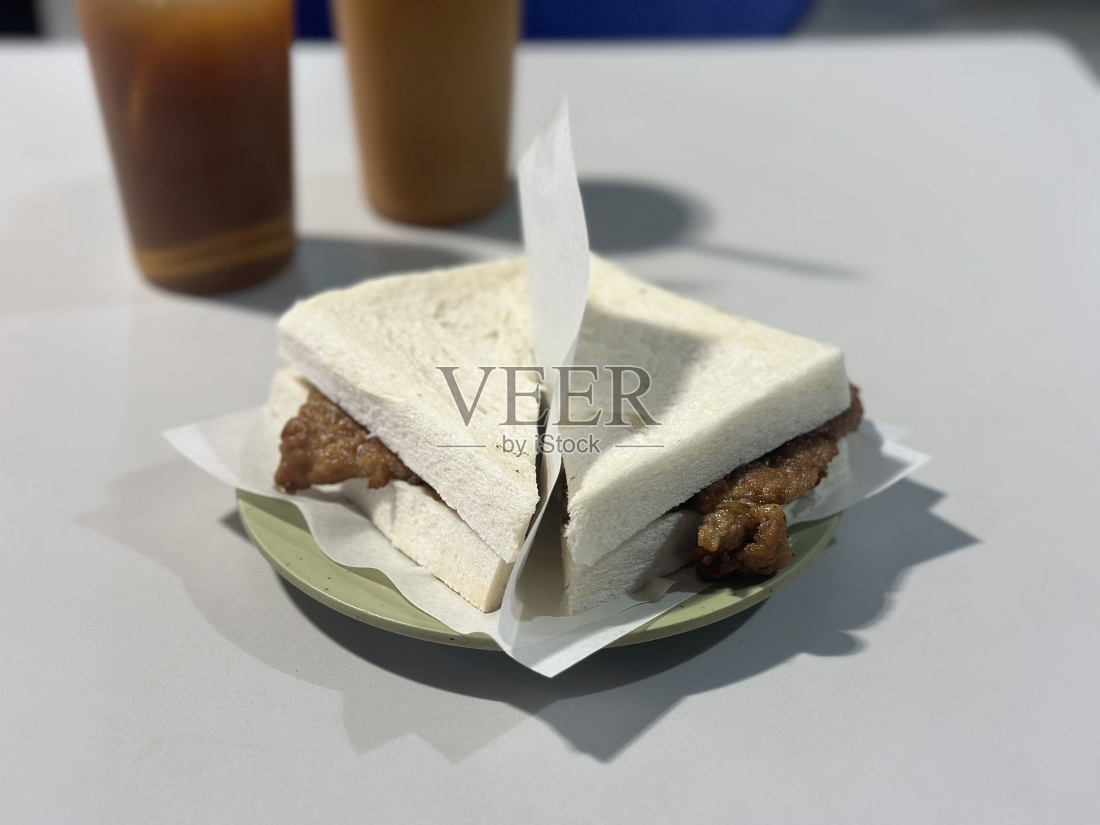 广东菜,猪排三明治,背景是饮料。关闭了。照片摄影图片