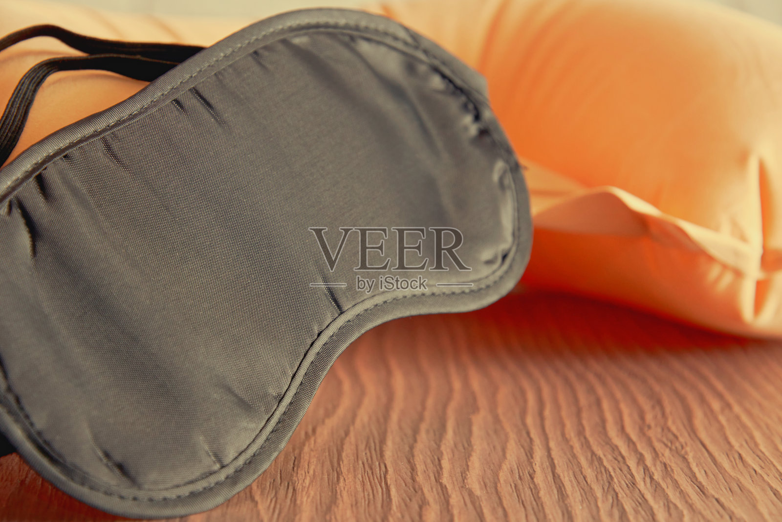 木桌上的脸眼罩和软颈枕照片摄影图片