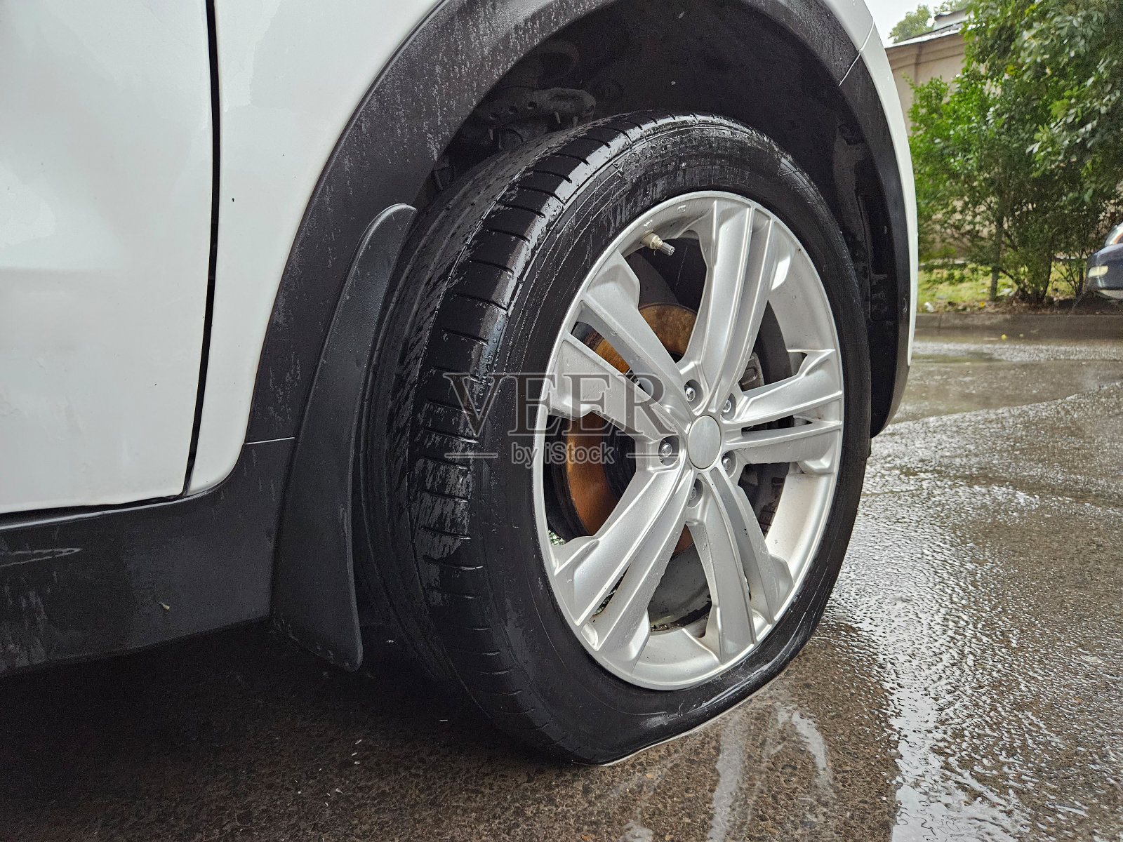 在潮湿的柏油路上,其中一个轮胎完全瘪了照片摄影图片