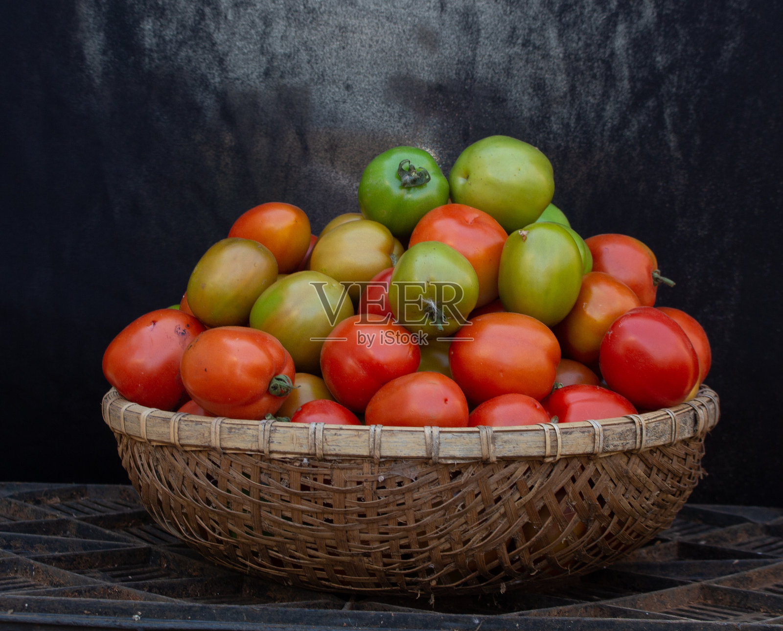 成熟和绿色的西红柿储存在竹篮里照片摄影图片