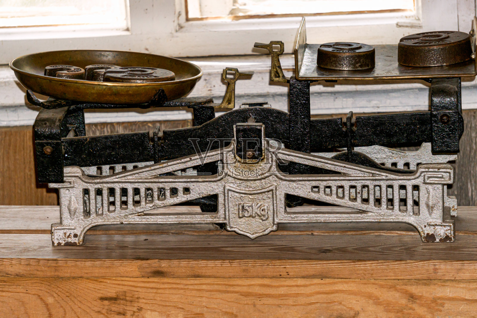 商店用的老式金属秤,木桌上放着砝码。照片摄影图片