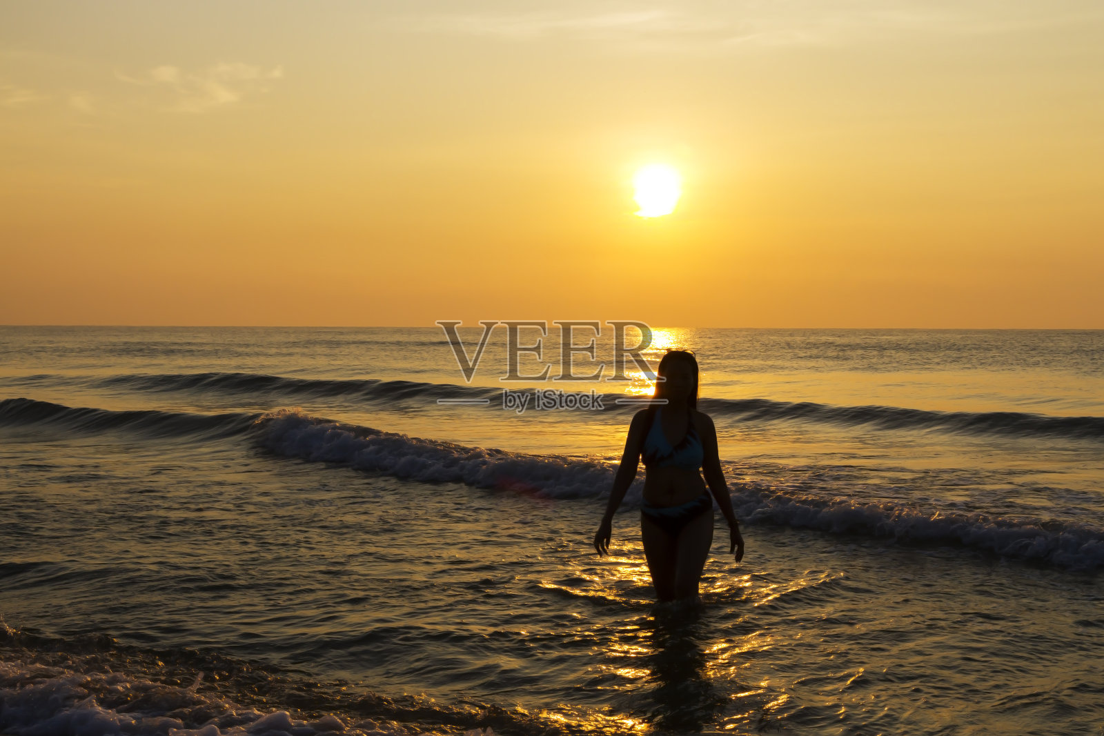 穿着比基尼的大女人和沙滩上的日出照片摄影图片