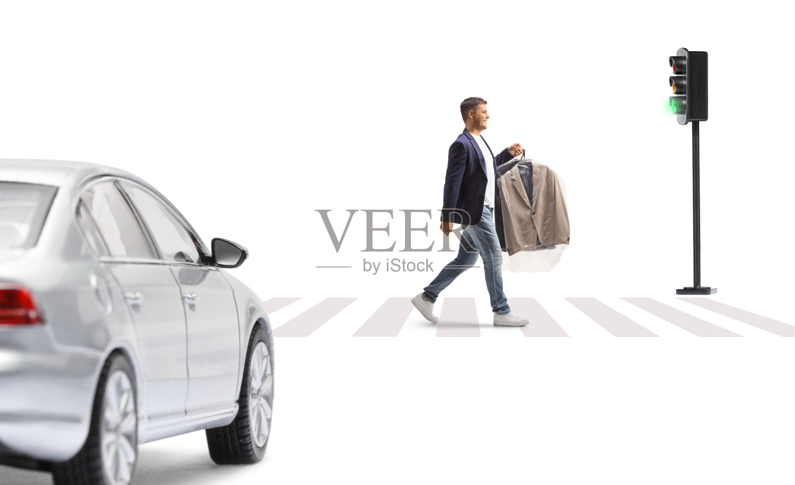 一名男子带着一套衣服和一个塑料干洗袋,在汽车在人行横道上等待时穿过街道照片摄影图片