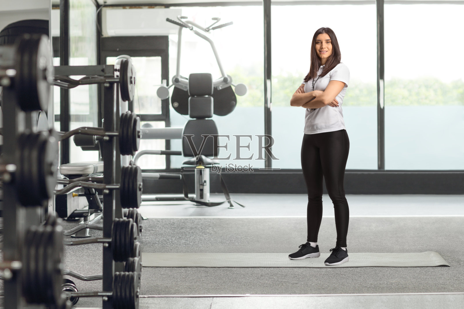 女健身教练在健身房摆姿势照片摄影图片