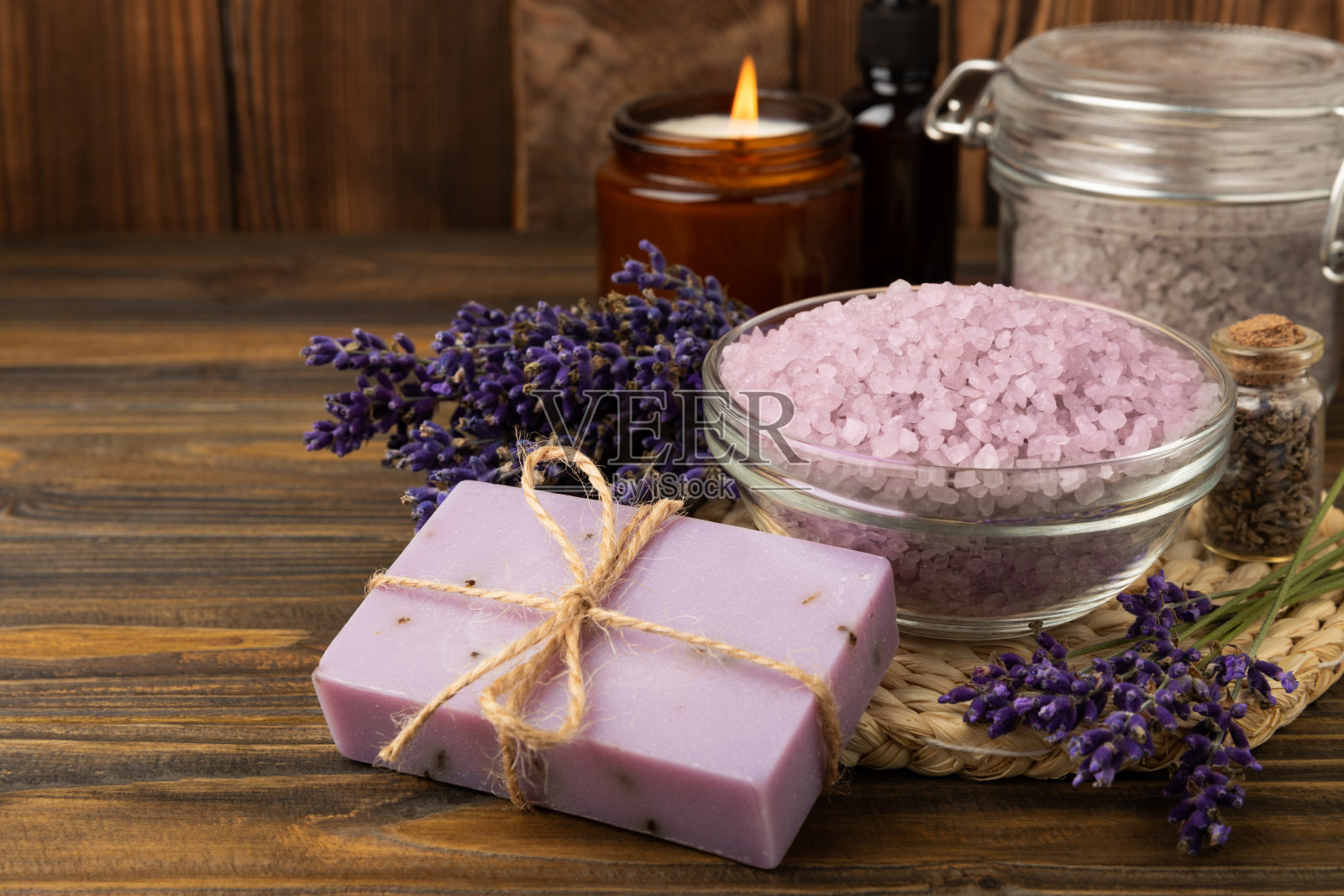 薰衣草温泉。海盐、薰衣草花、芳香蜡烛、身体乳和手工香皂。天然草药化妆品与薰衣草花大理石背景。放松的概念。美容。副本的空间。照片摄影图片