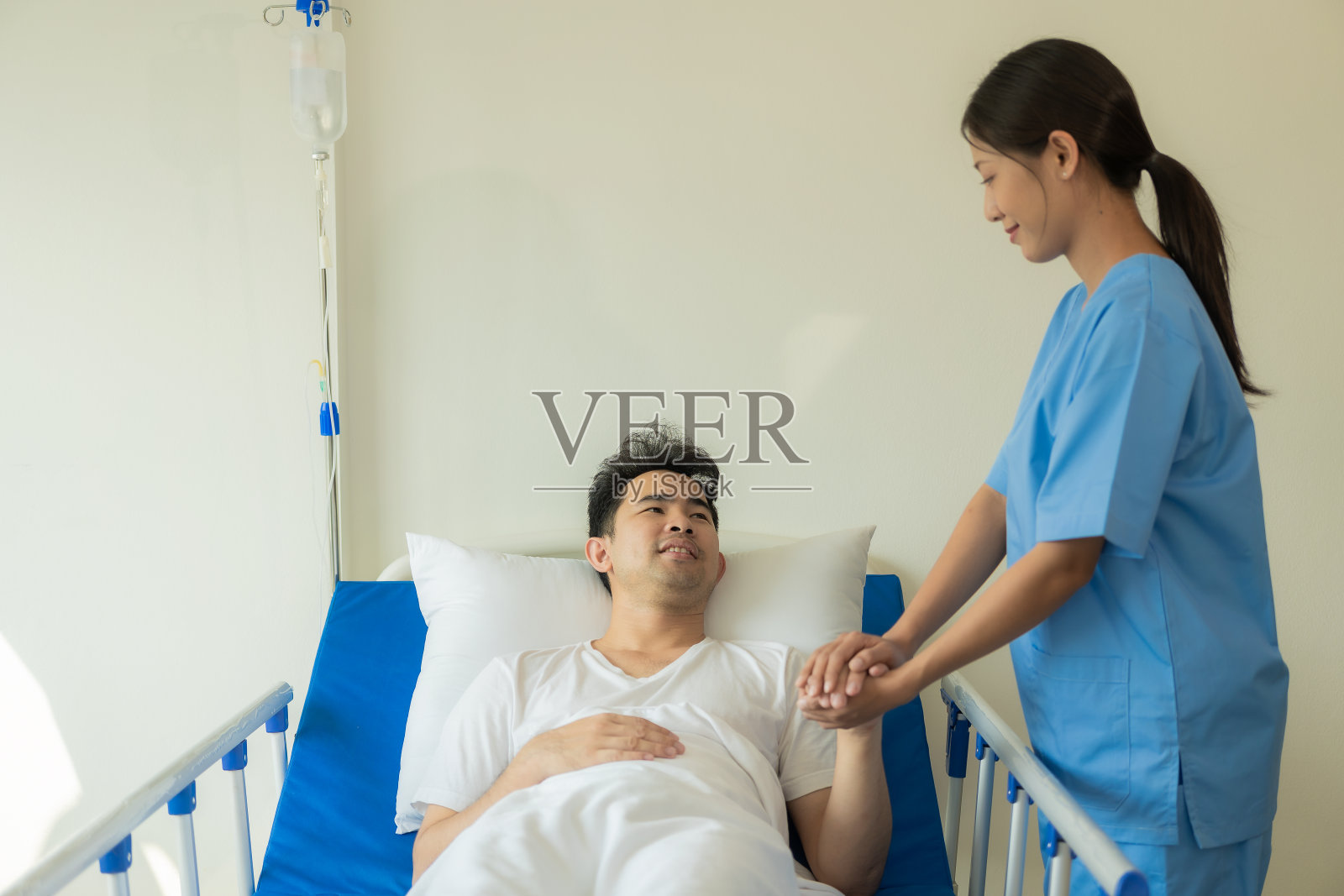 概念医院的亚洲男性病人躺在床上,医生检查和询问病情,女护士填写健康清单照片摄影图片