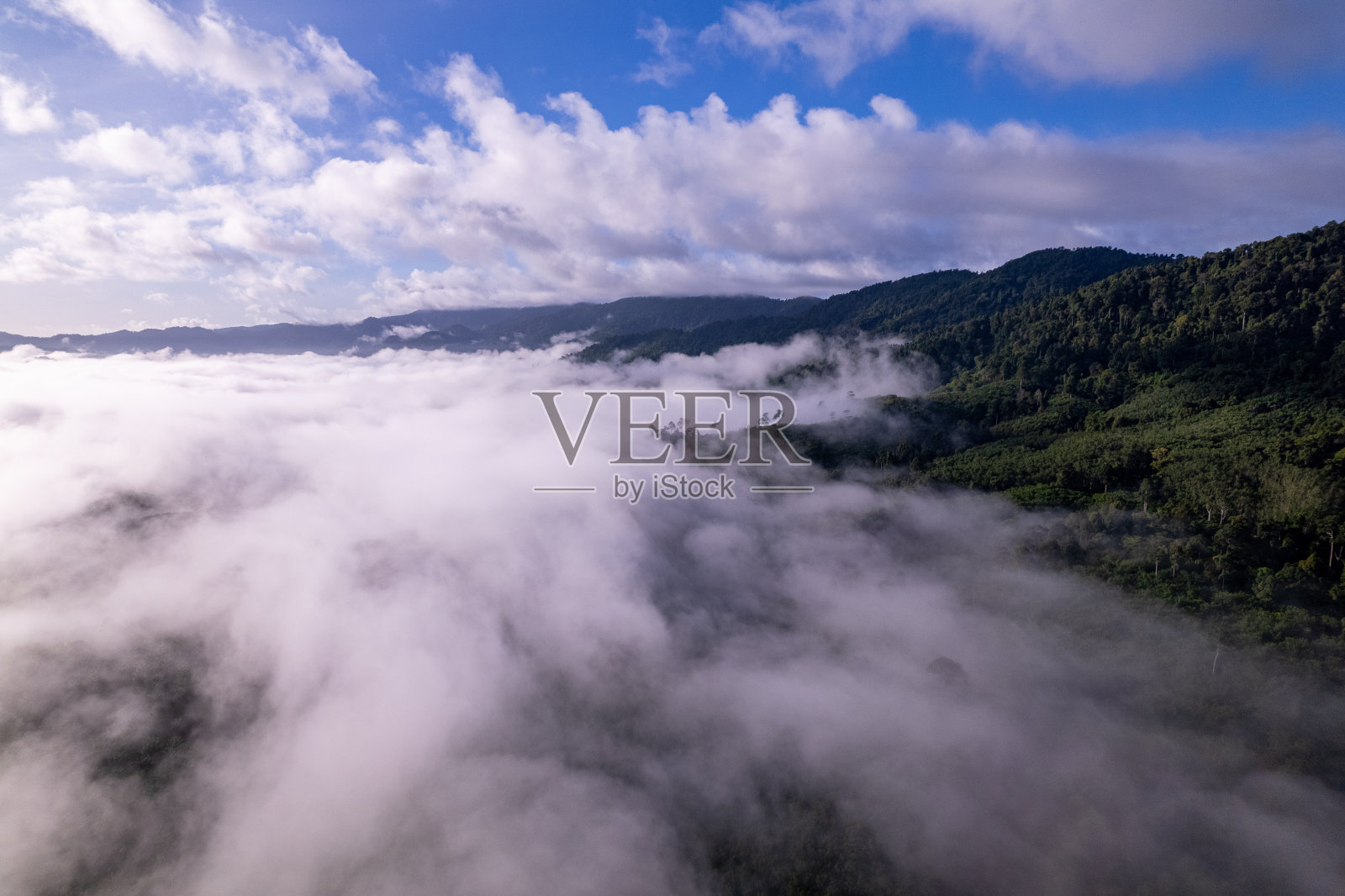 空中俯瞰的流动的雾波在山区热带雨林,云中鸟瞰图像在泰国的云和山峰令人惊叹的自然背景照片摄影图片