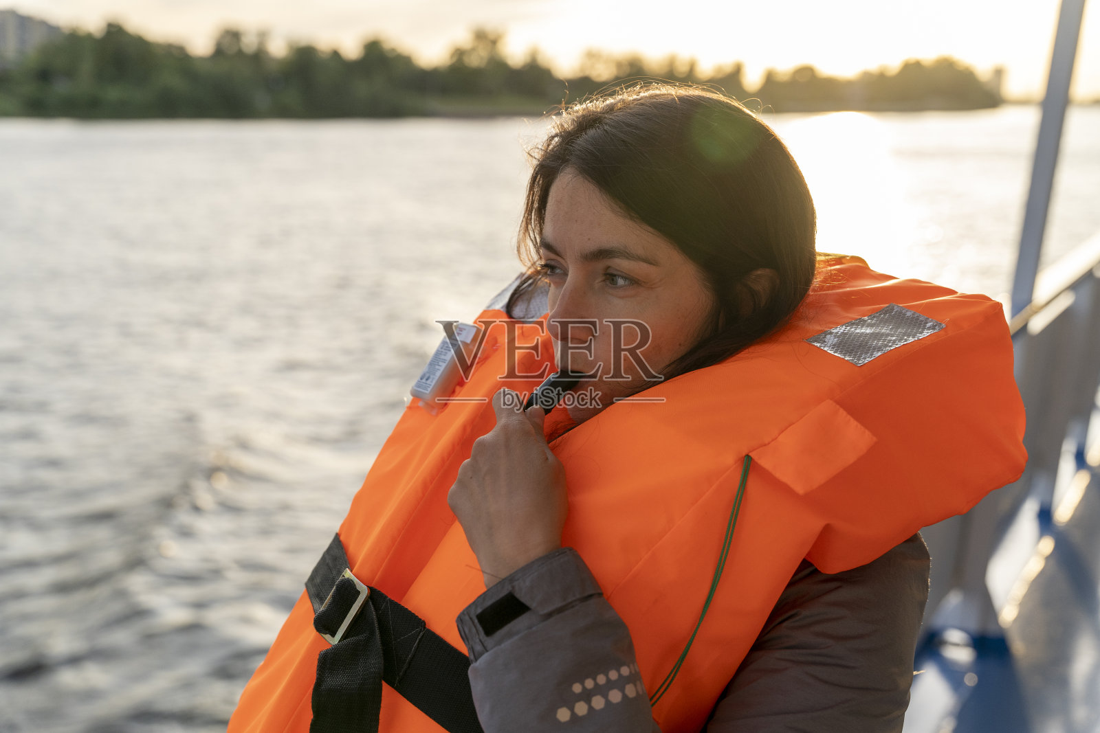 穿着橙色救生衣的妇女吹着口哨照片摄影图片