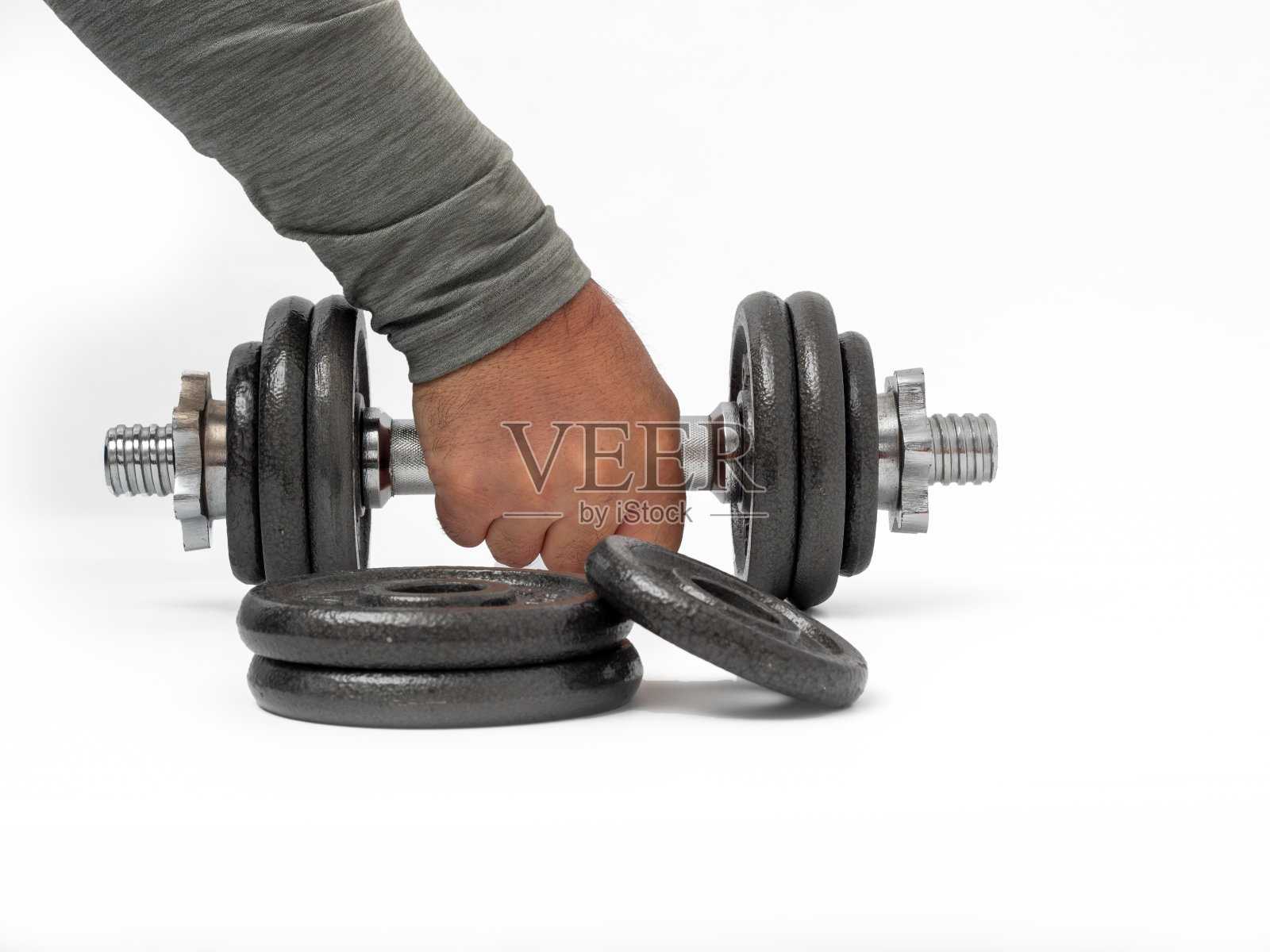 手里拿着一个白色背景的哑铃。照片摄影图片