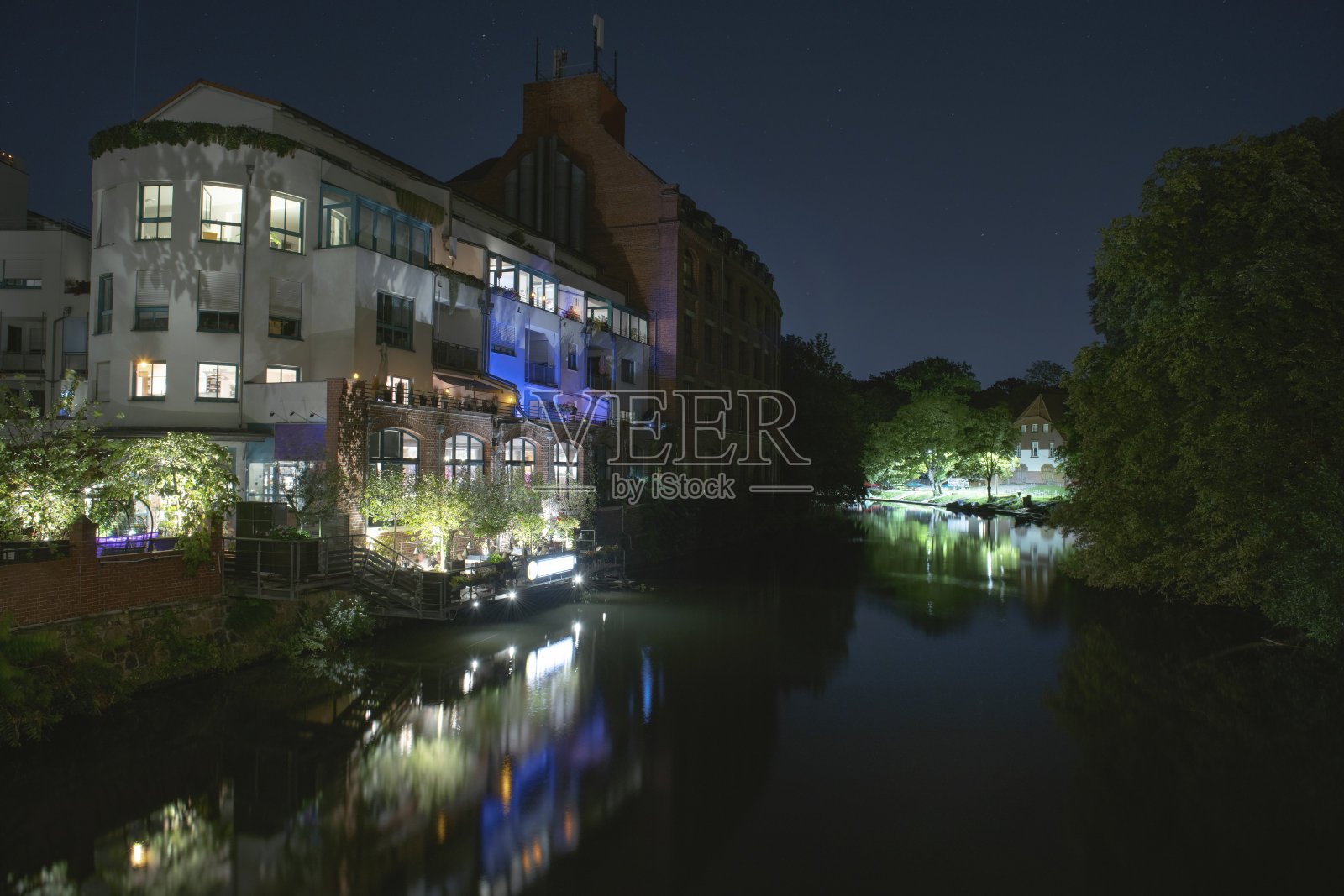 夜晚的古城。可以看到房屋、河流和公园。照片摄影图片