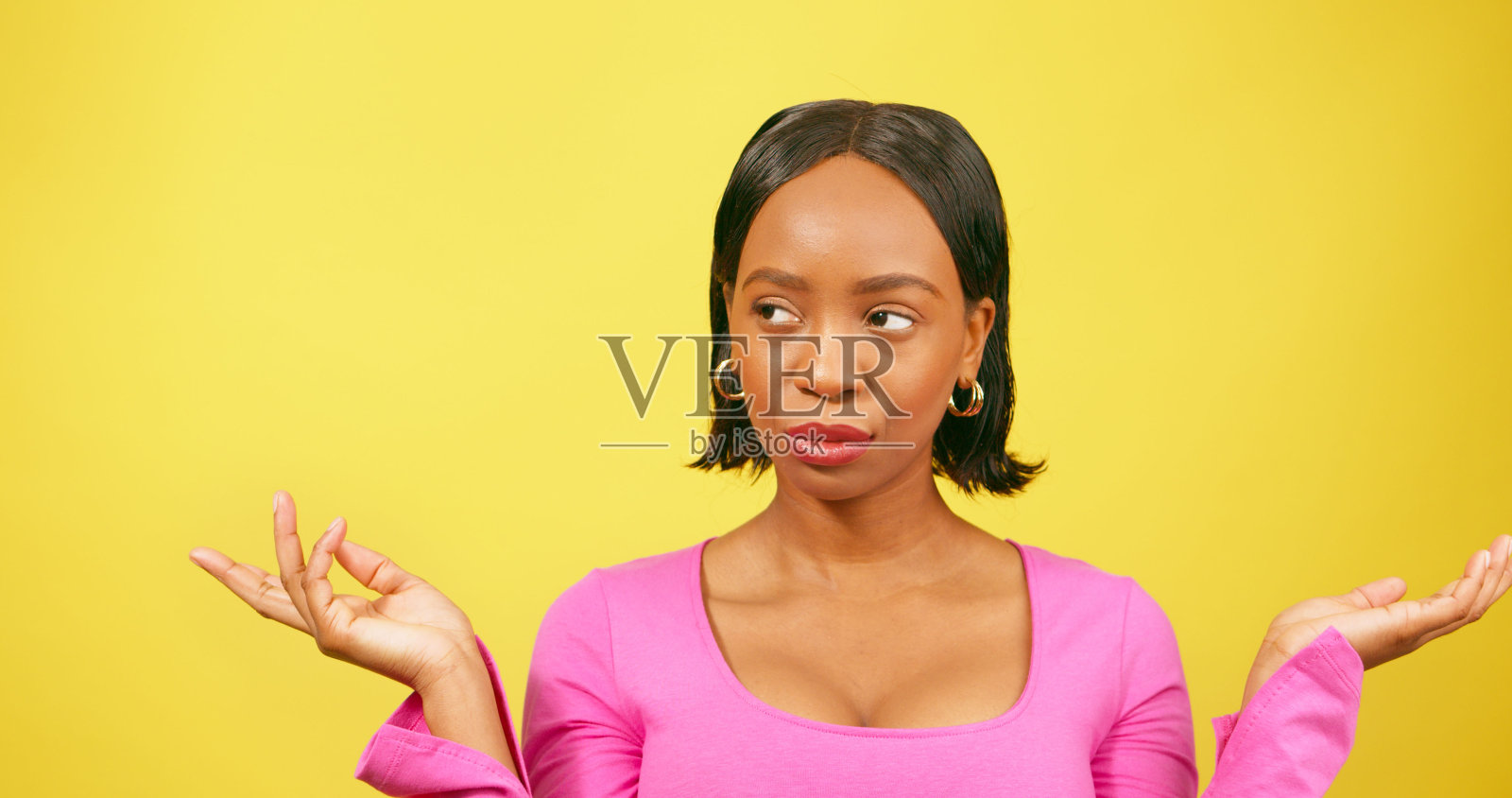 美丽的黑人女子耸耸肩,黄色的画室背景照片摄影图片