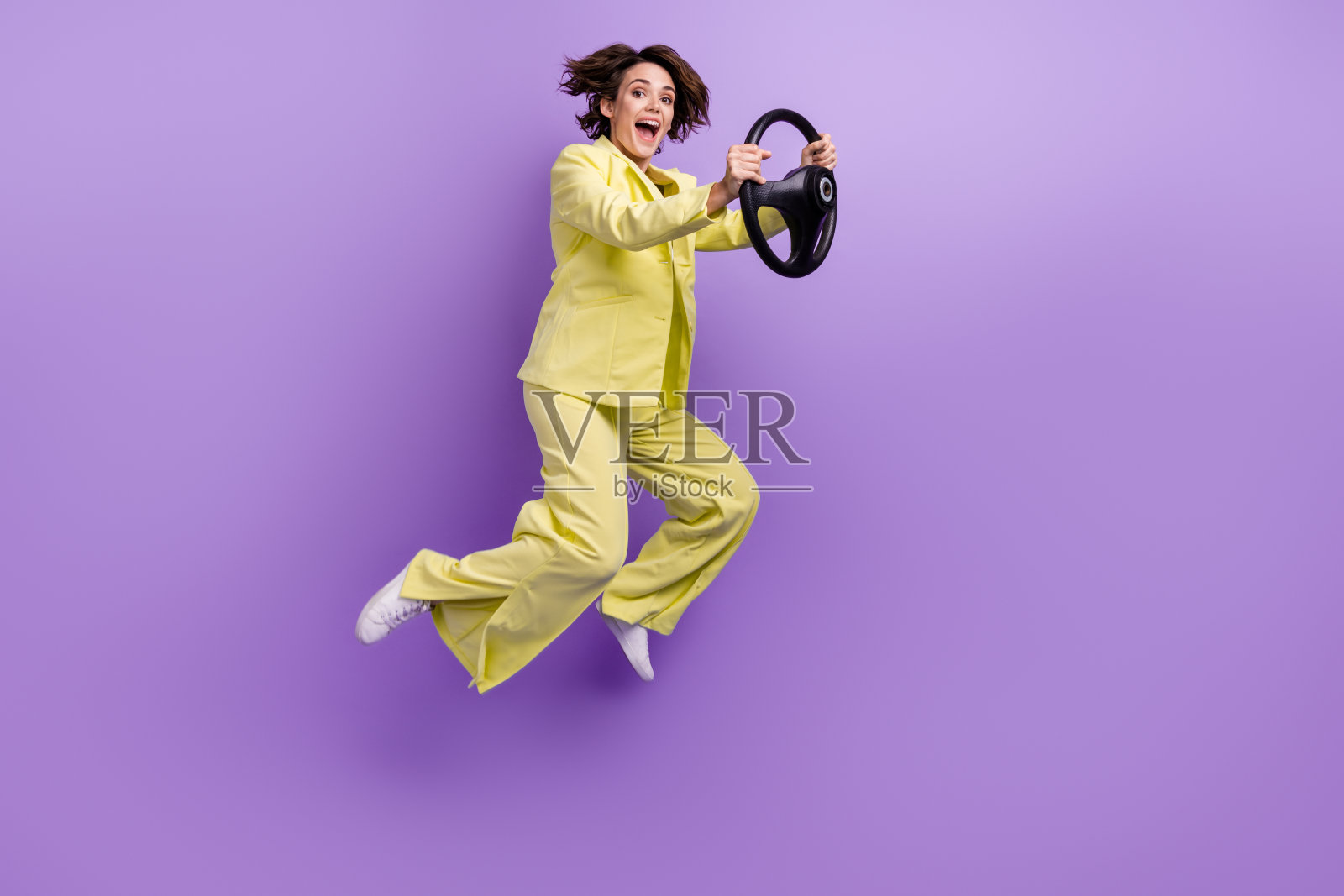 全身照片可爱的印象女士穿西装外套跳高驾驶车辆孤立的紫罗兰色背景照片摄影图片