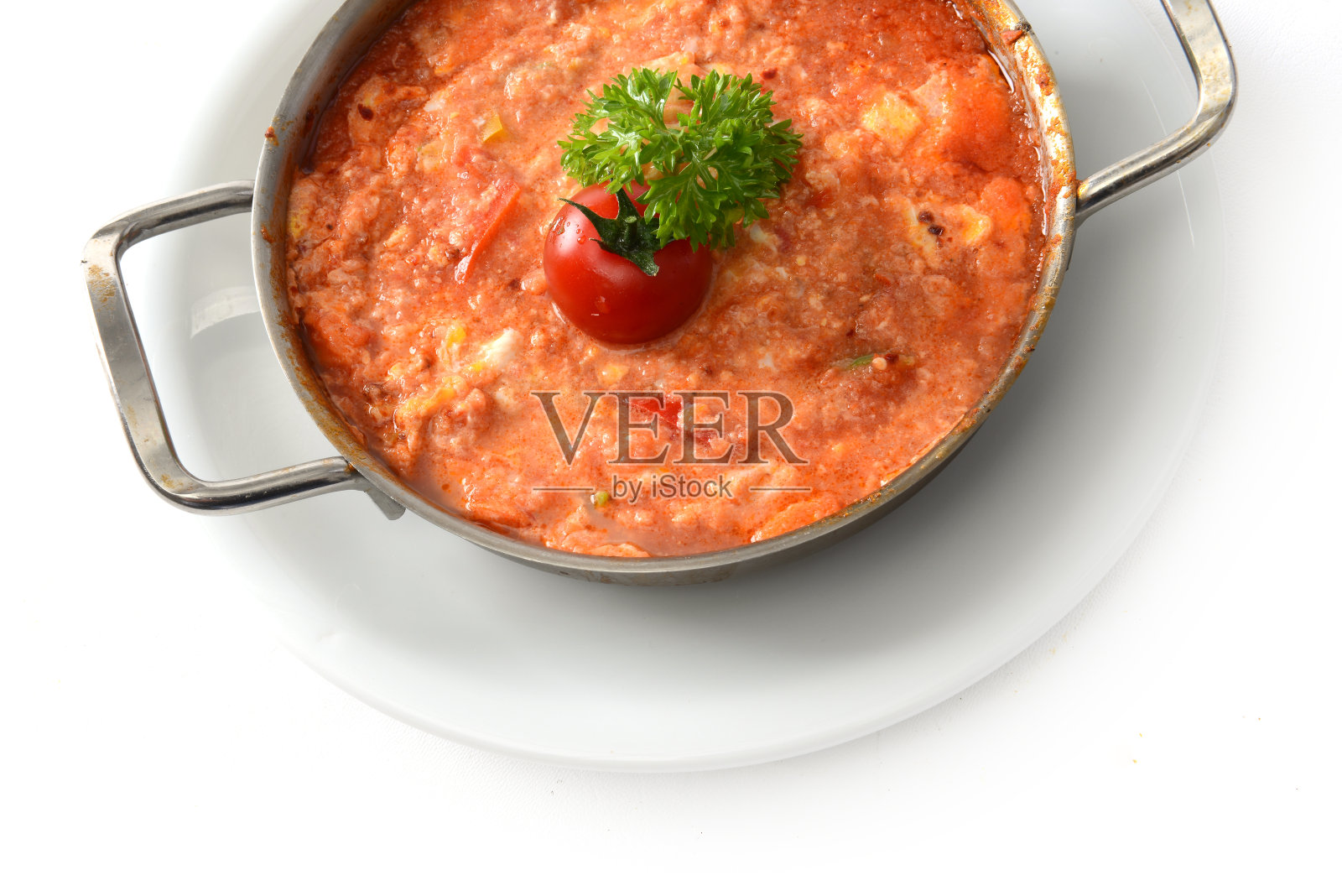 Menemen是一道特殊的土耳其蛋菜,用炒鸡蛋、西红柿和辣椒烹制而成,上面撒上西红柿和青菜照片摄影图片