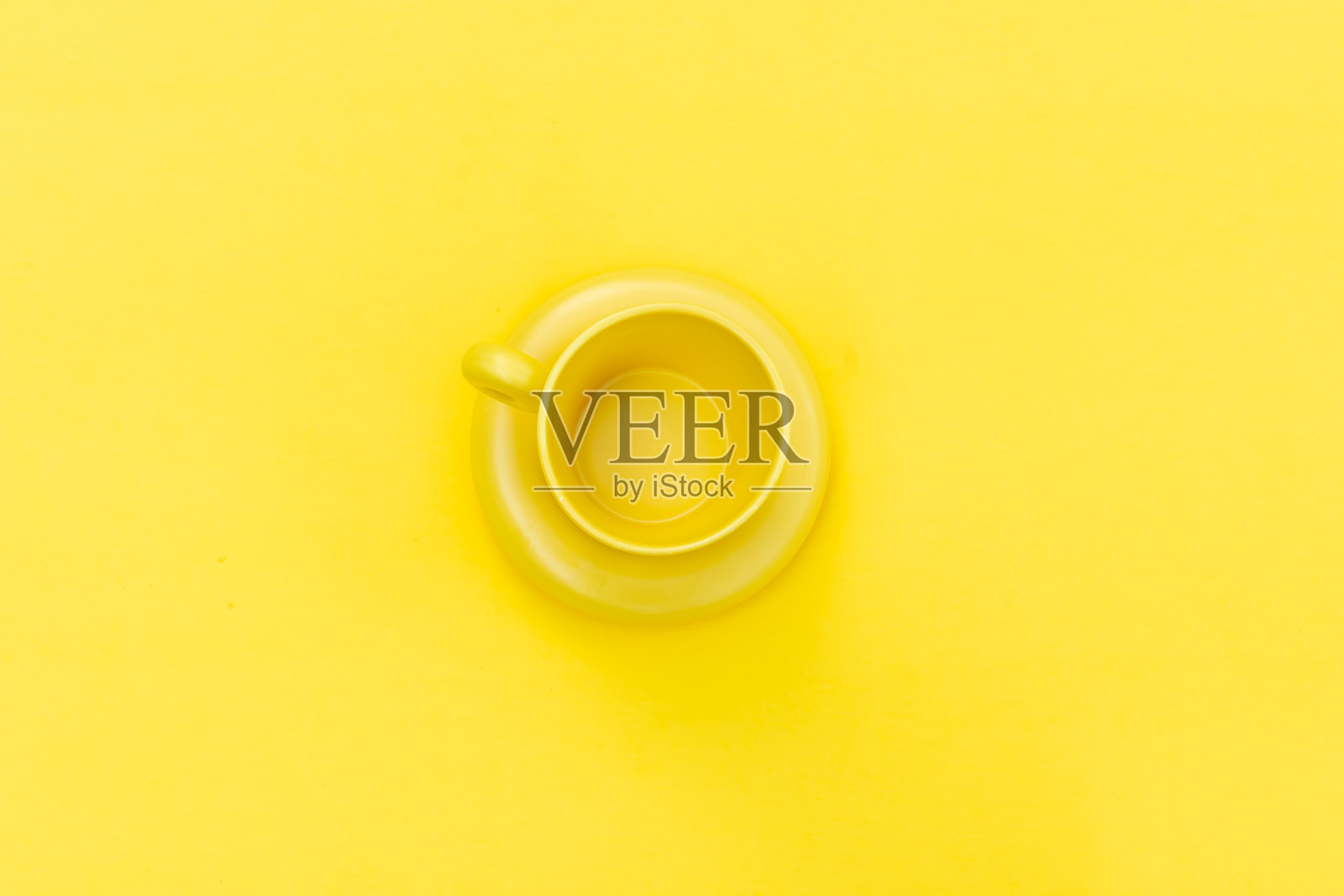 黄色背景上的黄色咖啡杯照片摄影图片