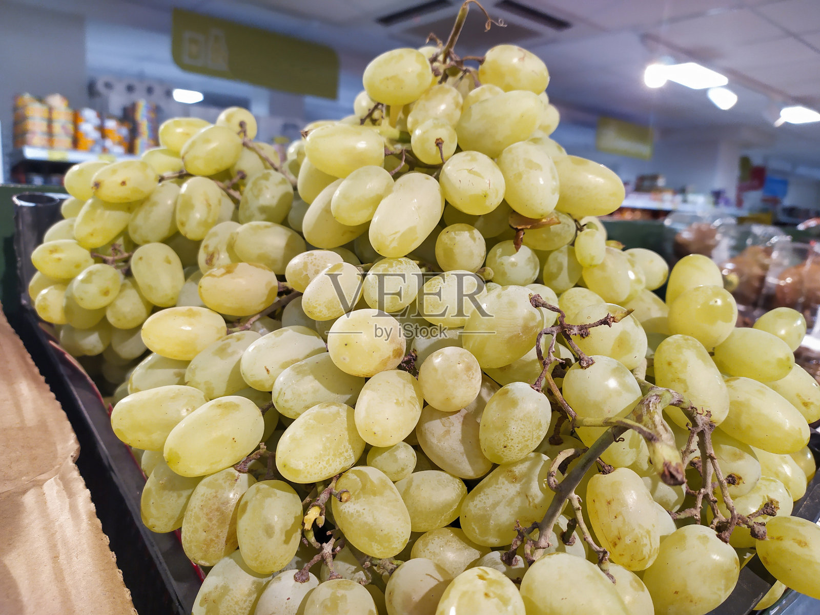 超市,商店或商店货架上的水果。新鲜成熟的葡萄放在架子上。健康生态食品理念。有机食品和农场食品。每周购物。有选择性的重点。插图。照片摄影图片