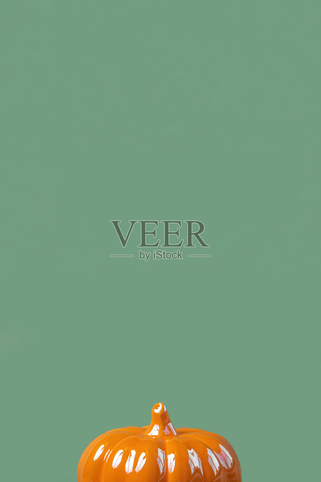 万圣节垂直背景与橙色南瓜。现代假日设计。秋天聚会边界上的橄榄绿自然颜色的背景。平铺,俯视图,复制空间。感恩节秋季时尚装饰照片摄影图片