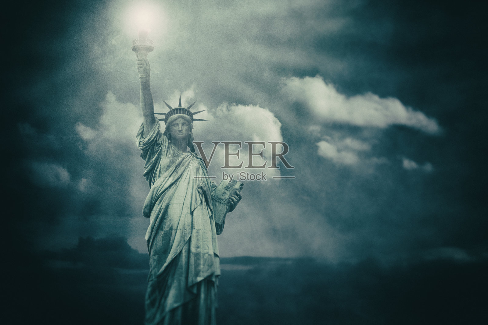 自由女神像与光束从它的火炬-背景图像与云照片摄影图片