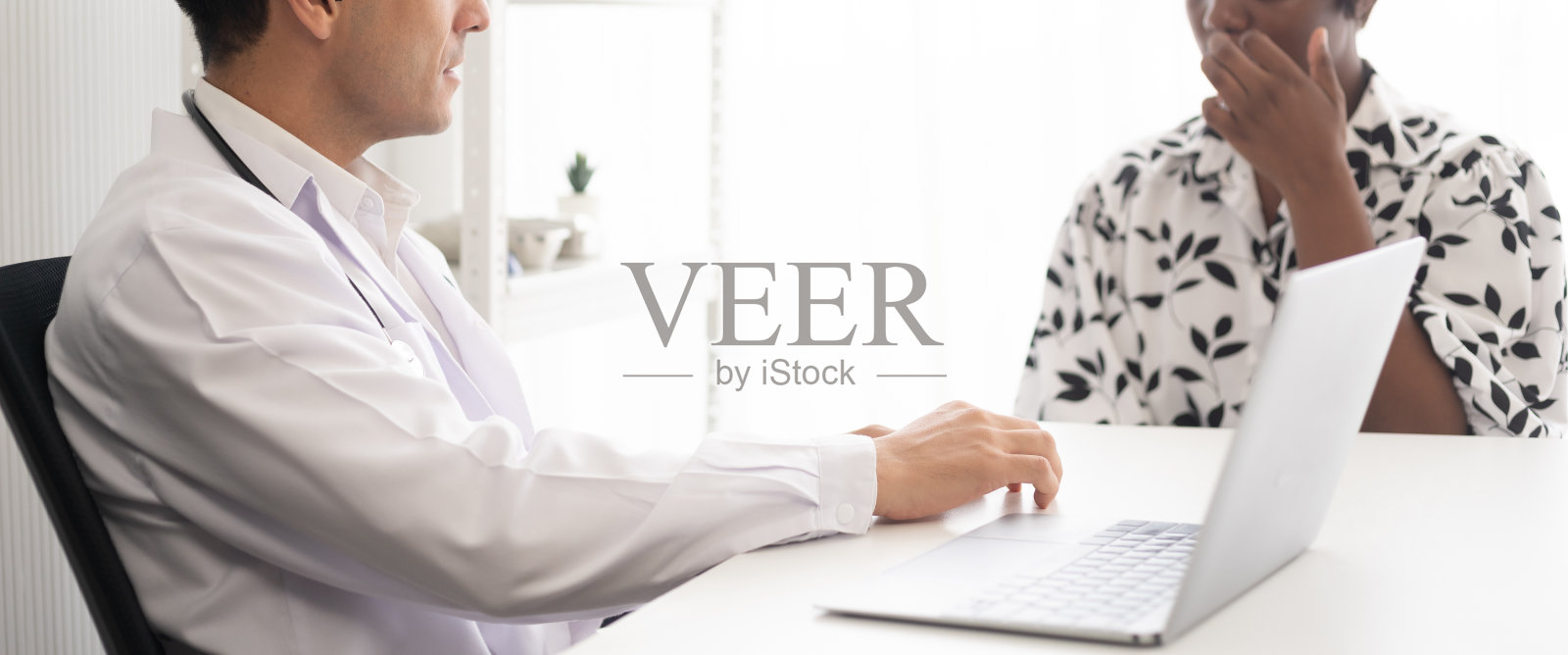 西班牙医生在医院用听诊器检查非裔美国病人。在笔记本电脑上进行医疗保健诊断和检查。照片摄影图片