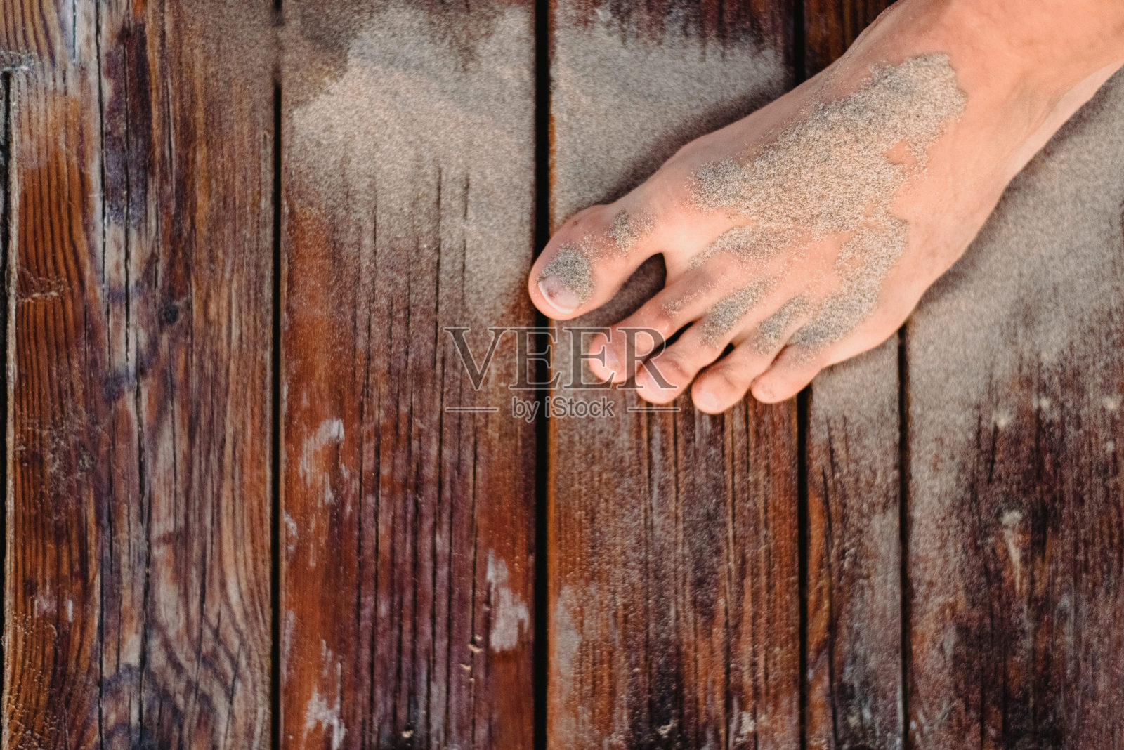 夏天的时候,脚被沙滩上的沙子弄脏了。照片摄影图片