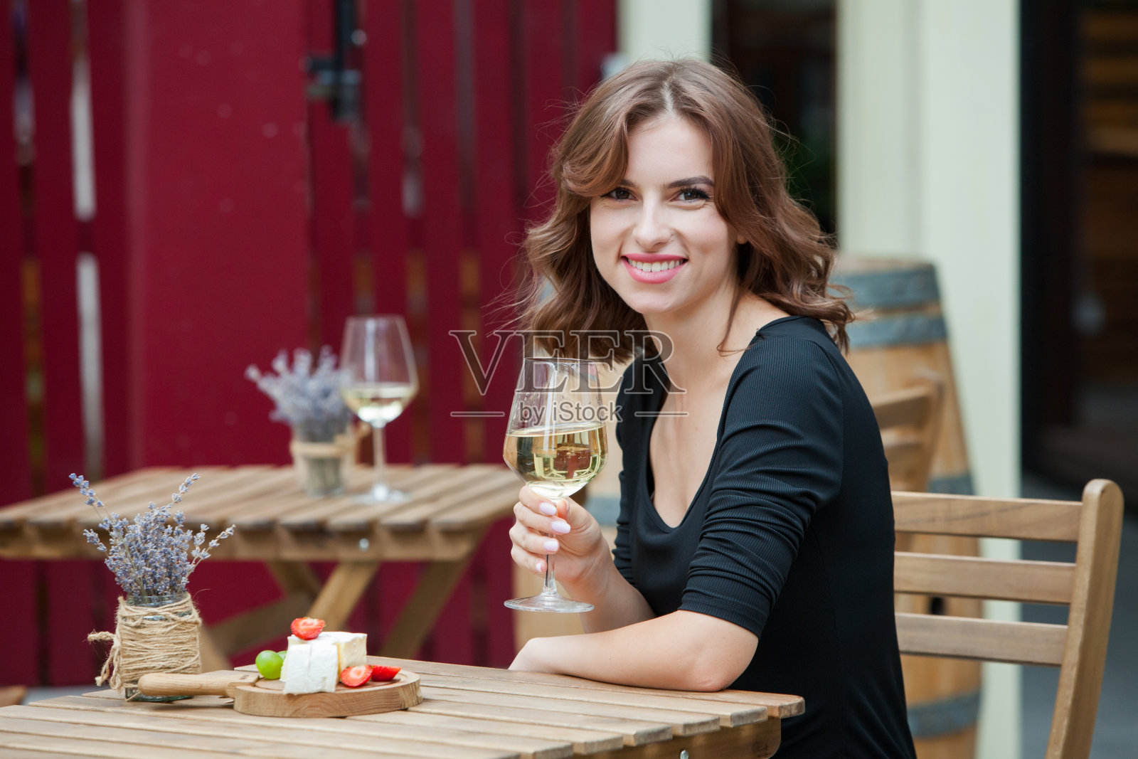 美丽的年轻女子在餐厅的露台上喝着白葡萄酒照片摄影图片