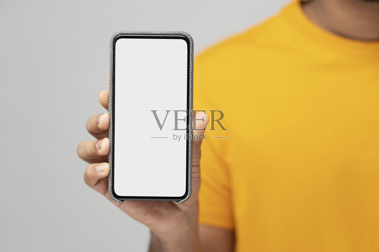 男子手持手机的特写与空显示屏,孤立在灰色背景,模型照片摄影图片