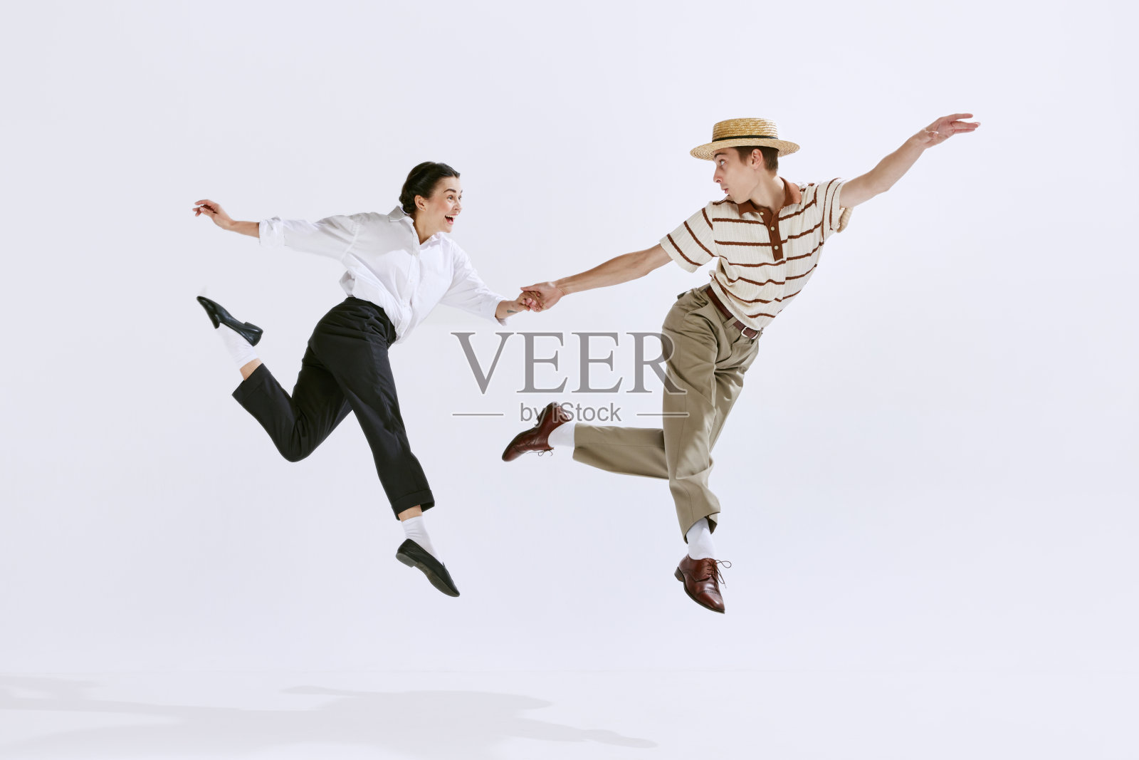快乐,有吸引力的年轻男子和女子在时尚的复古服装跳舞林迪跳孤立的白色工作室背景照片摄影图片