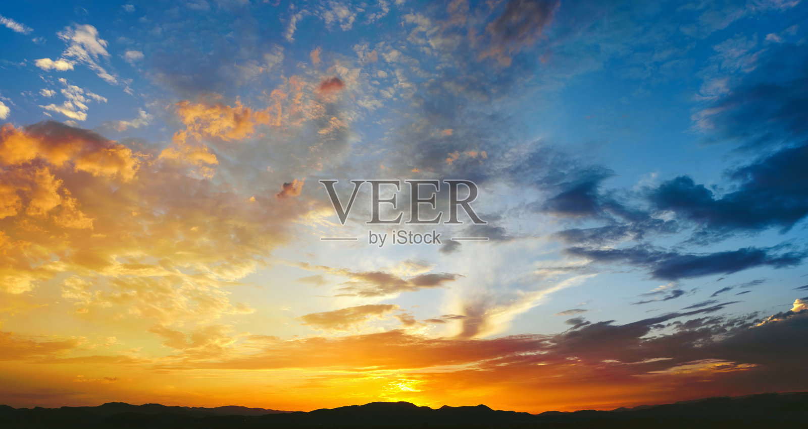 美丽的日落,橙色的太阳背后的山和深蓝色的天空照片摄影图片